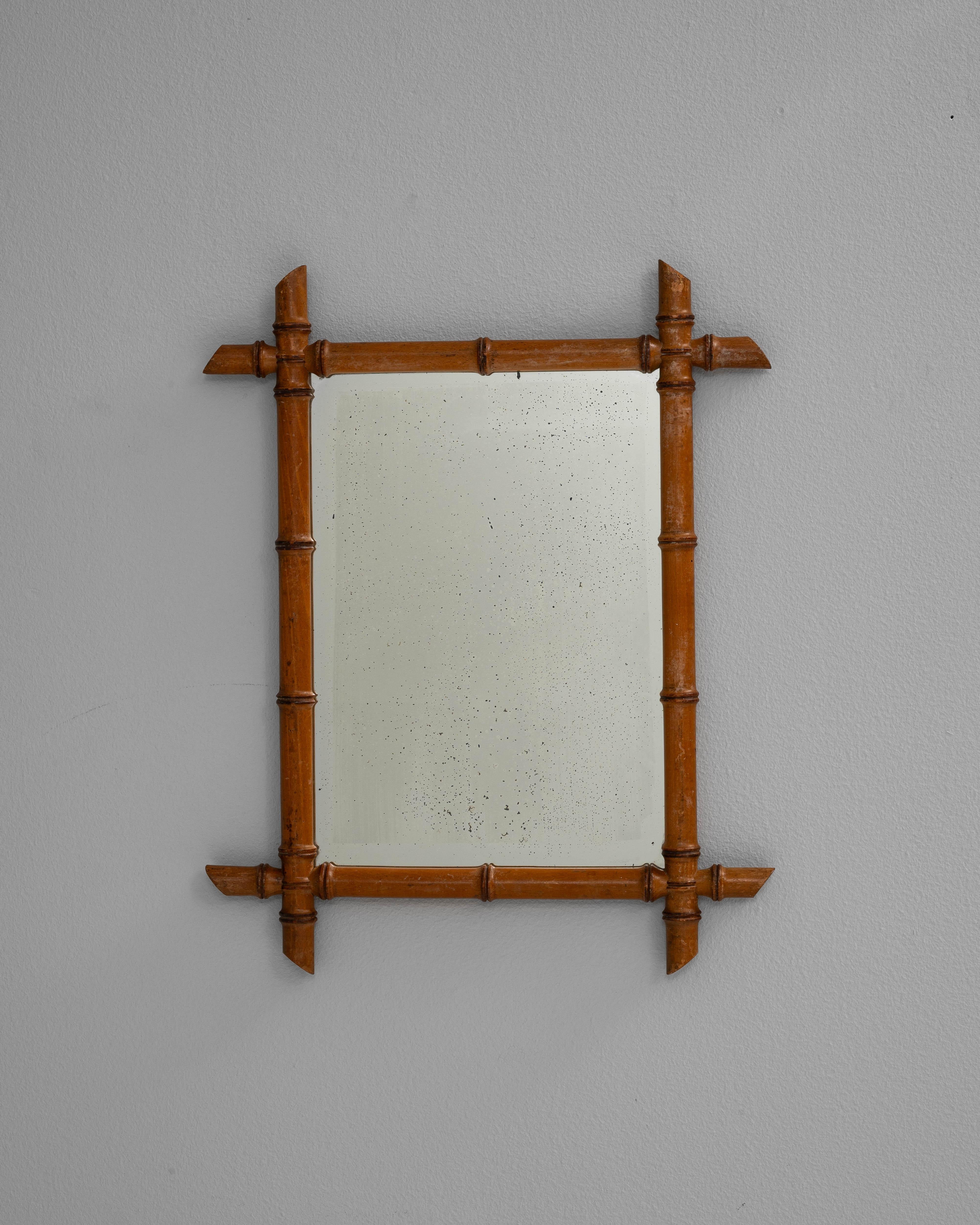 Este espejo francés del siglo XIX presenta un encantador marco de imitación de bambú, que captura el exótico atractivo del bambú a través de la madera finamente tallada. El cálido acabado en tonos miel y la delicada carpintería reflejan la