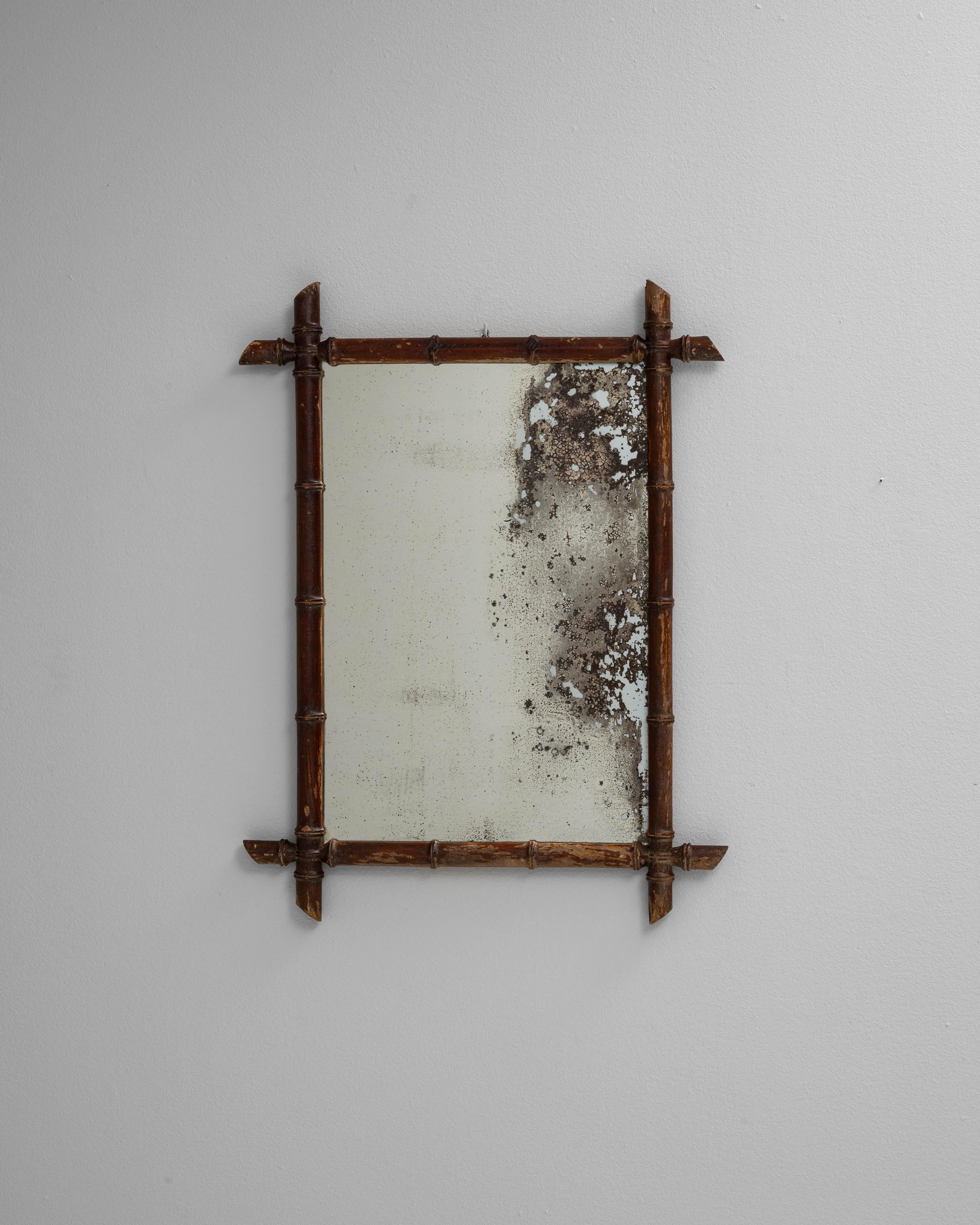 Este espejo francés de imitación de bambú del siglo XIX presenta un marco de madera tallada diseñado para imitar la apariencia del bambú, mostrando la fascinación de la época por los motivos exóticos y las formas orgánicas. El espejo rectangular