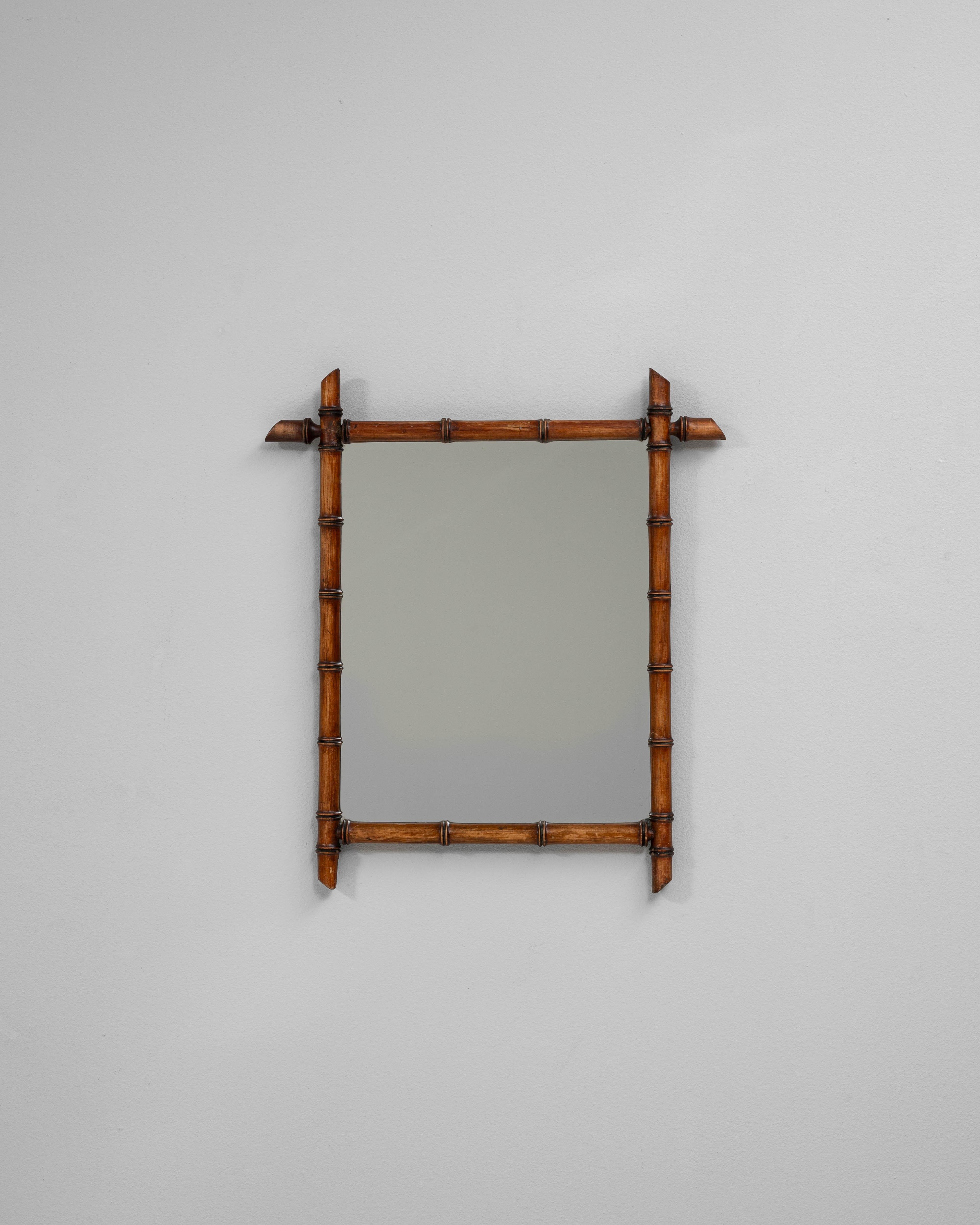 Questo specchio in finto bambù francese del XIX secolo riflette l'affascinante influenza del giapponismo che ha attraversato le arti decorative europee alla fine del 1800. La struttura in legno intagliato imita il bambù naturale con notevole