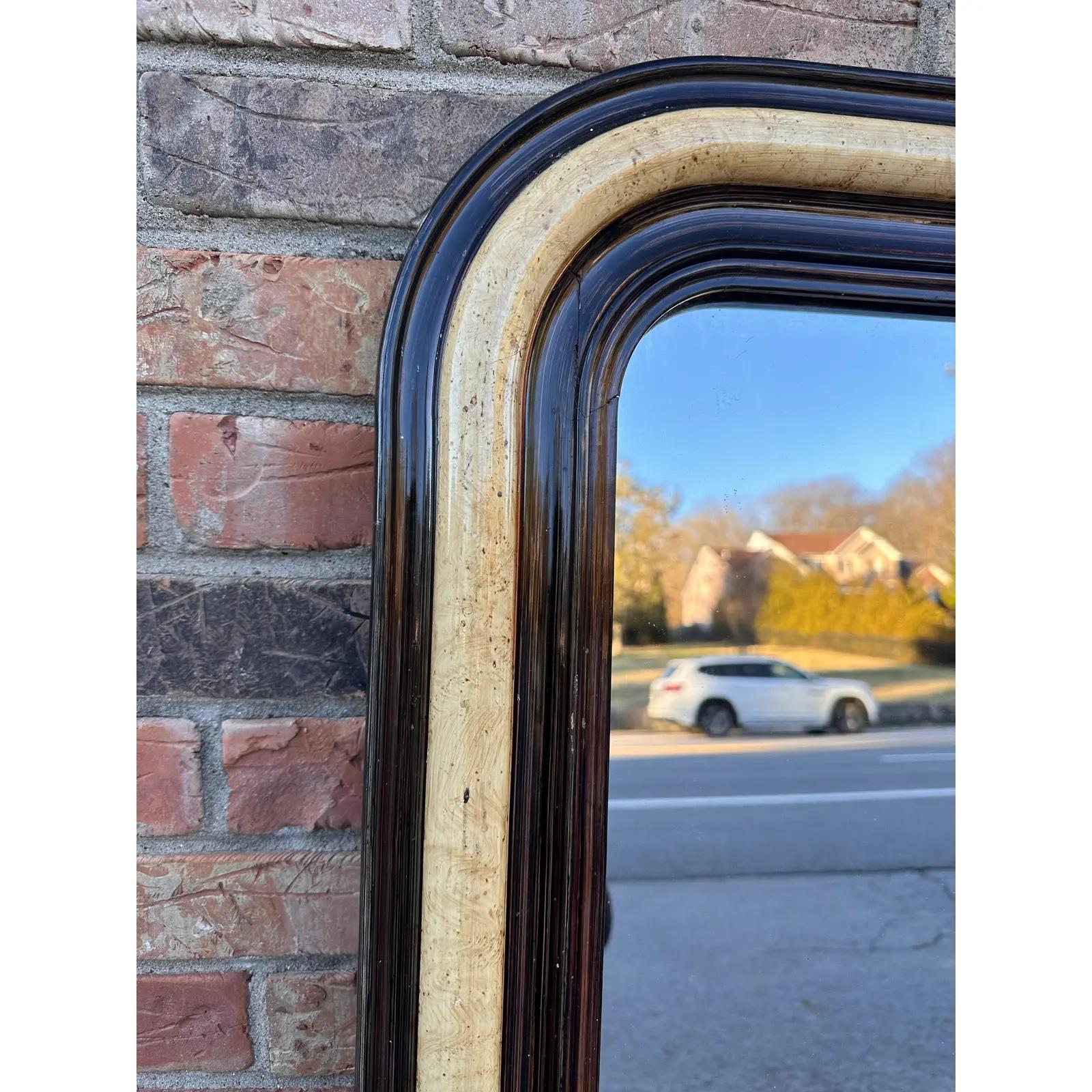 This is a stunning antique mirror! This piece has an ebonized outer and inner border which serves to accent the beautiful band of faux wood in the center. The colors of this piece complement each other perfectly, with the deep tones of the outer