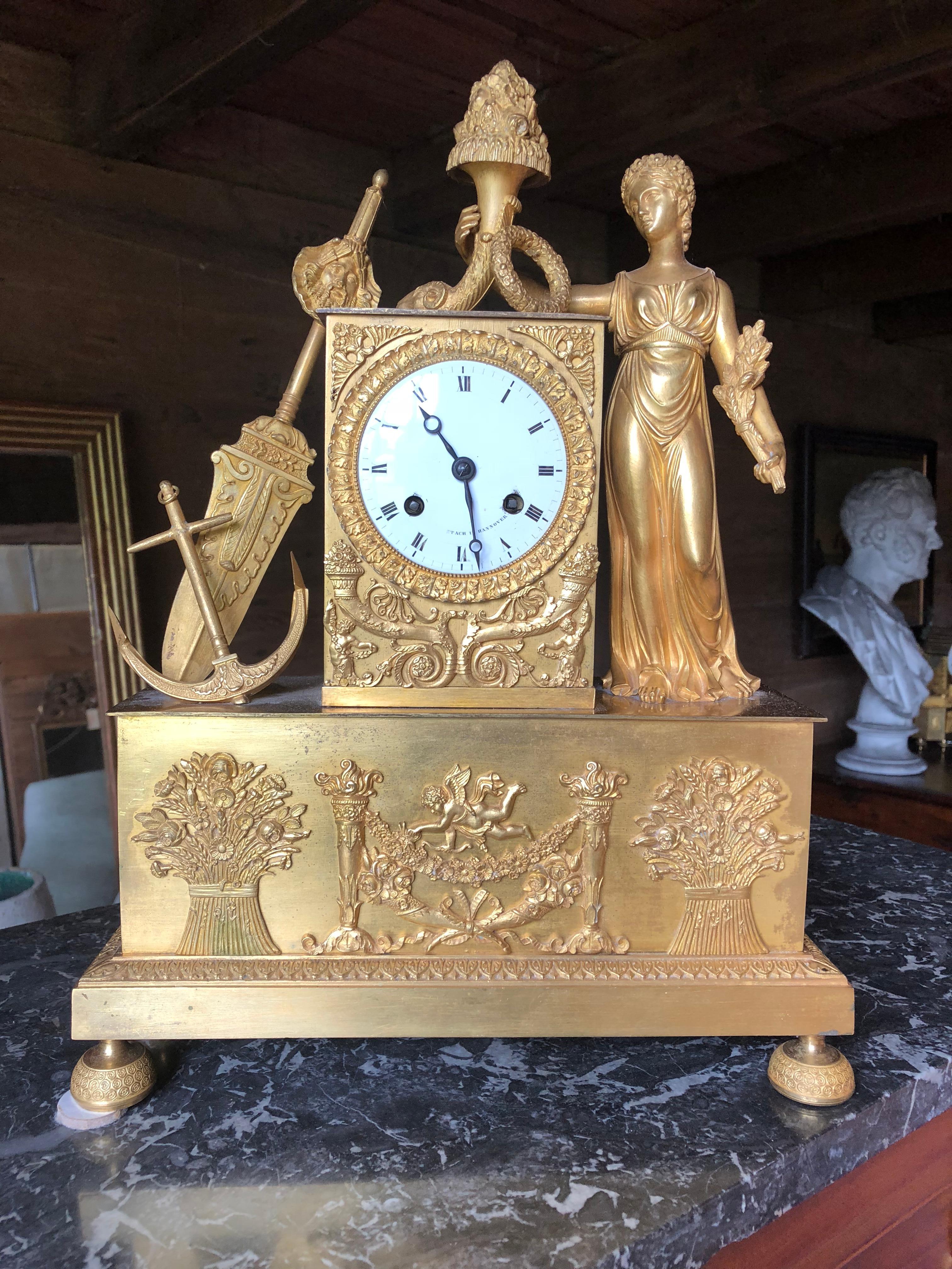 An unusual French figural mantel clock of the early 19th century, in the neoclassical manner, depicting a Maritime theme with woman holding a cornucopia, with a large anchor and sword beside the central clock face. The pedestal has two sheafs of