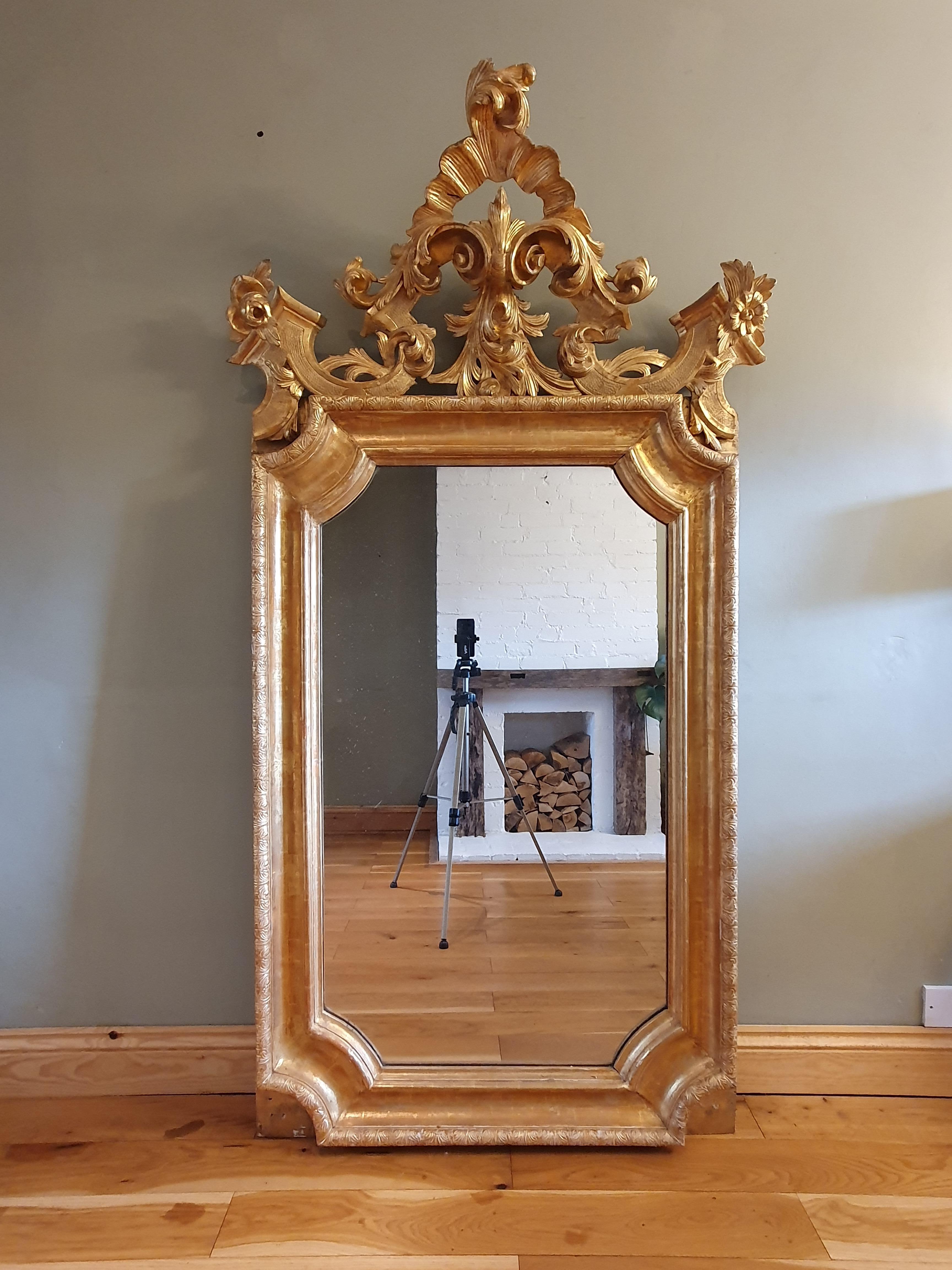 Miroir mural en bois doré, très impressionnant, datant du milieu du 19e siècle, avec des motifs en gesso tout autour du cadre principal (typique des miroirs du 18e siècle), et un beau plateau en bois sculpté. Plaque de miroir au mercure d'origine,
