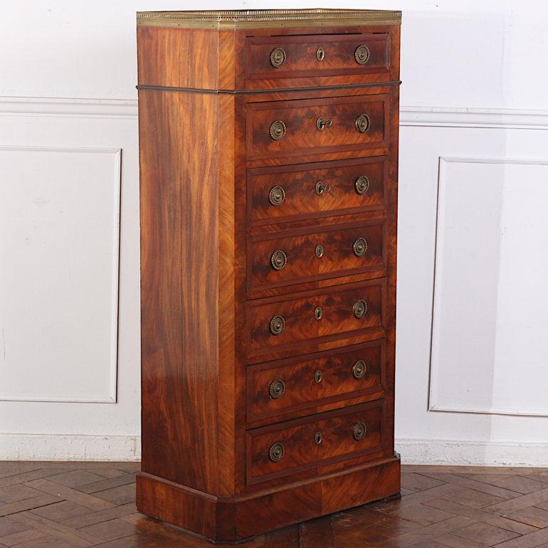 French flame mahogany seven drawer chest or semainier, each drawer with book-matched flame mahogany front and the original brass pulls. Fall-front desk with fitted bird's-eye maple interior concealed behind two 'faux' drawer fronts. Pierced brass