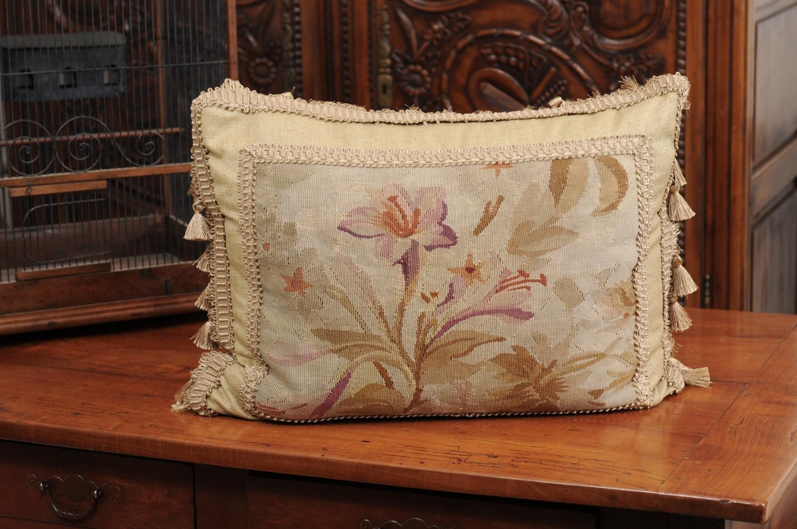 A French pillow made from 19th century Aubusson tapestry, with floral decor, gallon trim and tassels. Made from an exquisite tapestry created during the 19th century in the Aubusson manufacture located in central France, this horizontal pillow is