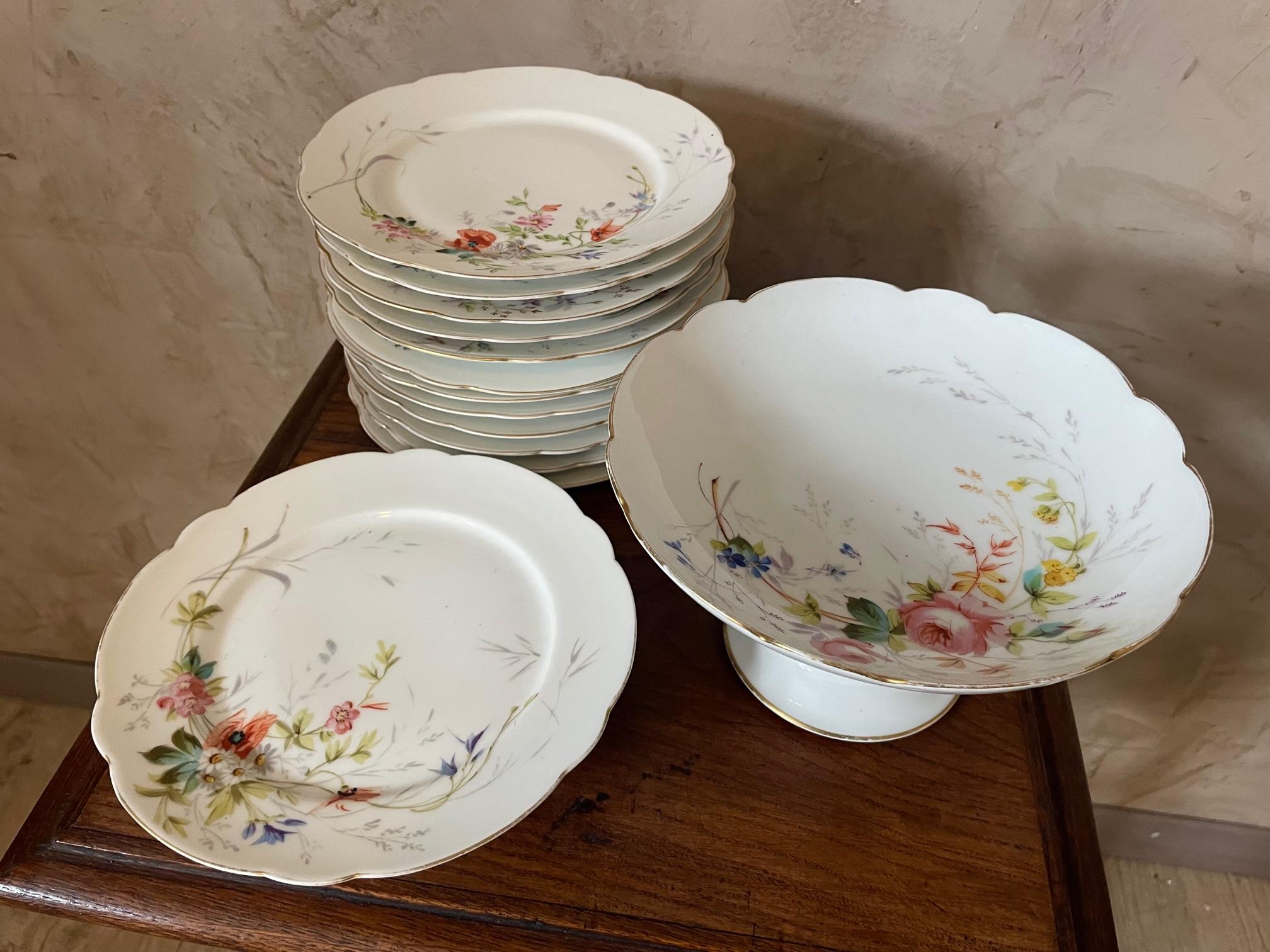Sehr schönes Set aus handbemalten Porzellantellern im Landhausstil mit Goldrand. Sie stammt aus dem 19. Jahrhundert, aus der Zeit Napoleons III. 
12 flache Teller, eine Obstschale und eine Standschale.
Eine Platte leicht gechipt der Rest ist in