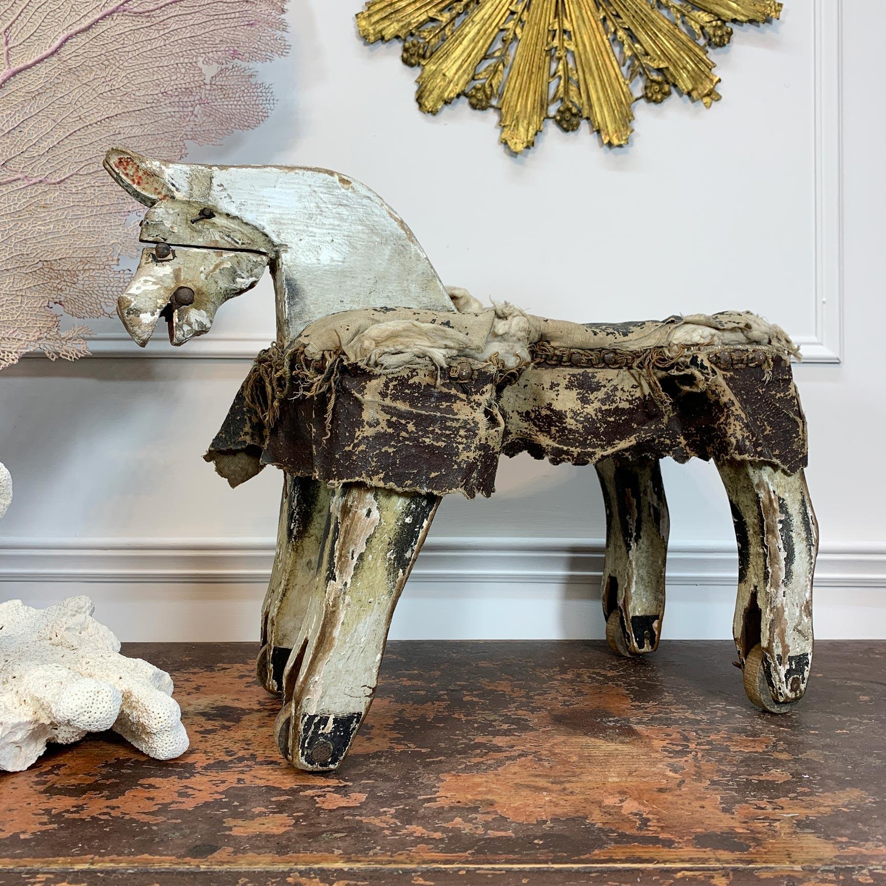 Charming French Folk Art Horse, mounted on naïve wooden wheels with a padded fringed leather saddle and dating to the mid-19thCentury. Superb detailing, this is a well-loved, well used and utterly delightful piece of primitive hand-crafted folk art.