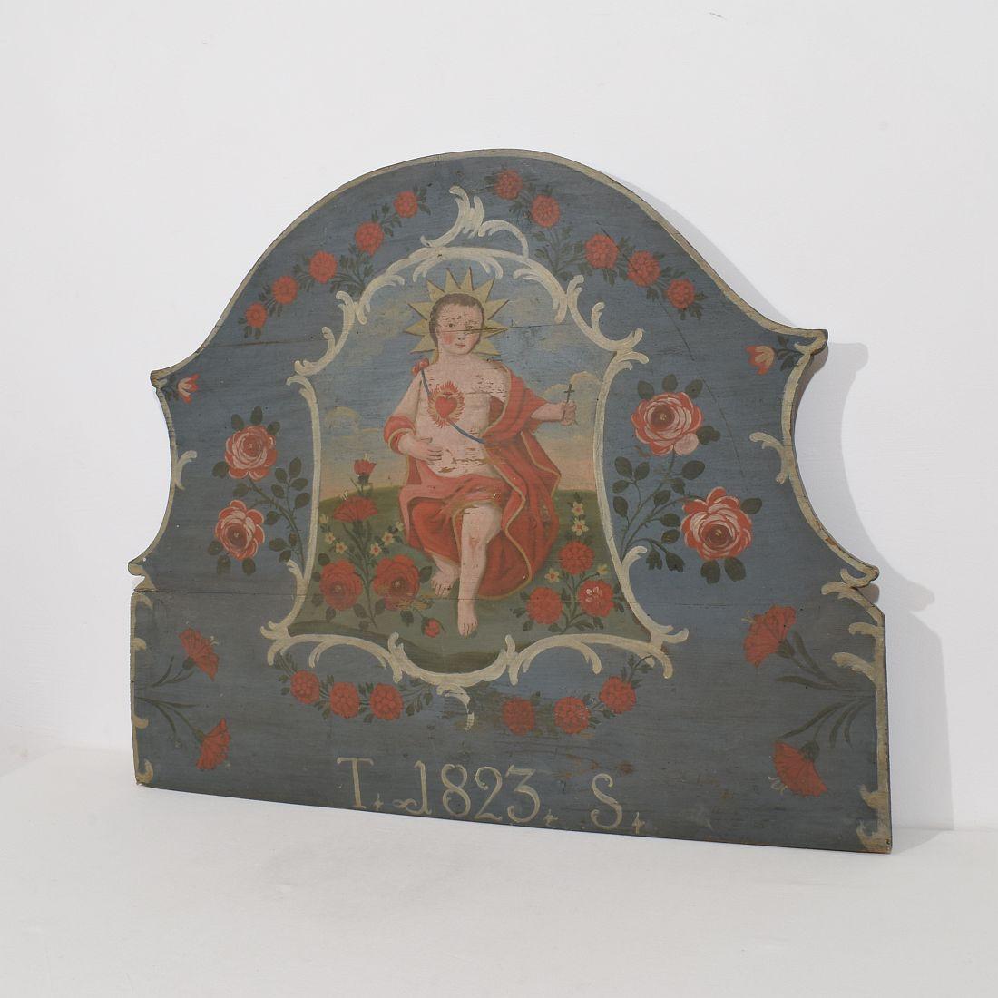 Très beau panneau en bois d'art populaire avec une très riche décoration de fleurs et une figure du Christ au centre.
France, daté de 1823. Météorisé. H:64,5cm  L:92cm P:3,5cm D'autres photos sont disponibles sur demande.