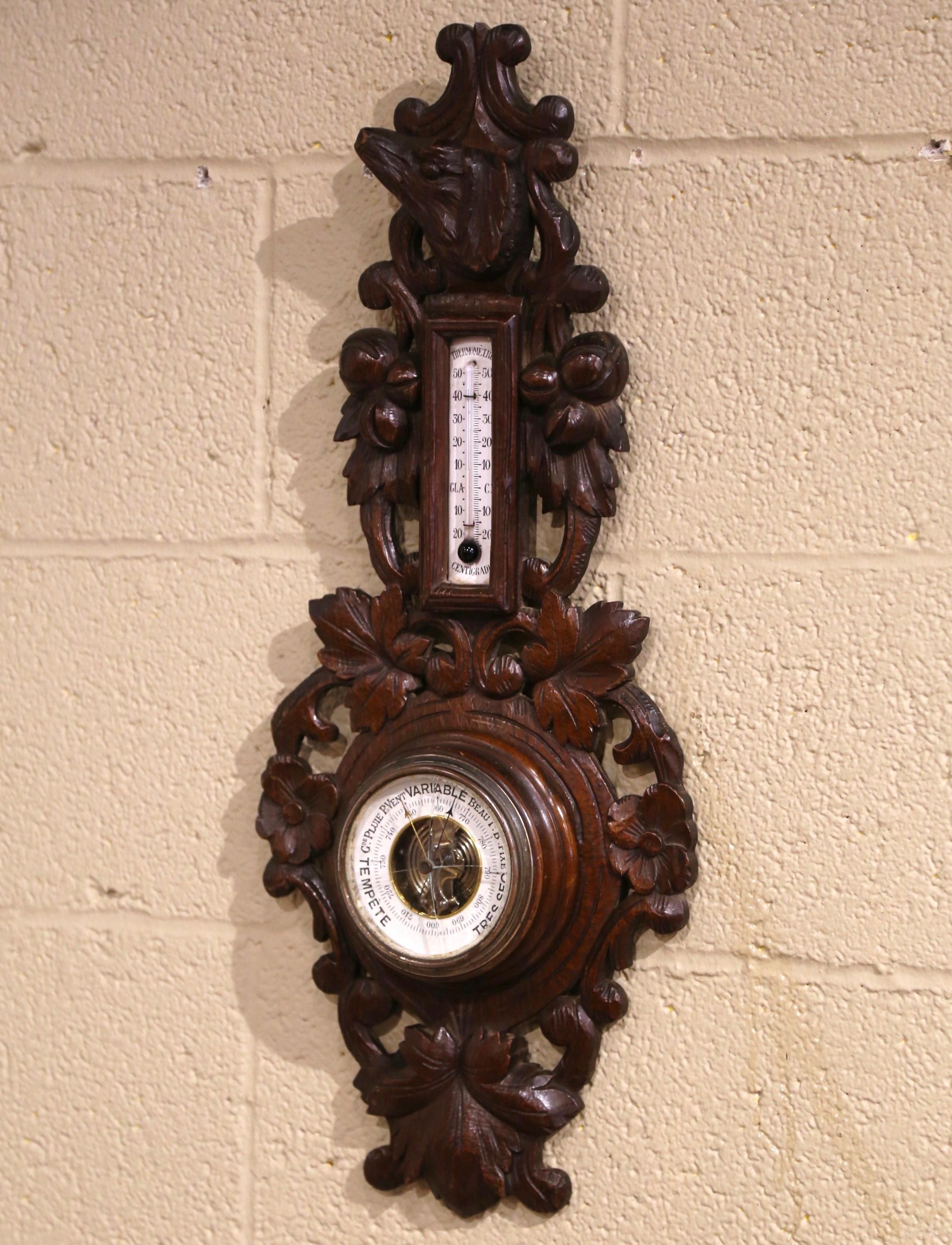 This elegant antique wall hanging barometer and thermometer was crafted in France, circa 1890. The carved oak weather and temperature reader features impressive, high-relief carvings of acorn and leaf motifs throughout; it is further embellished