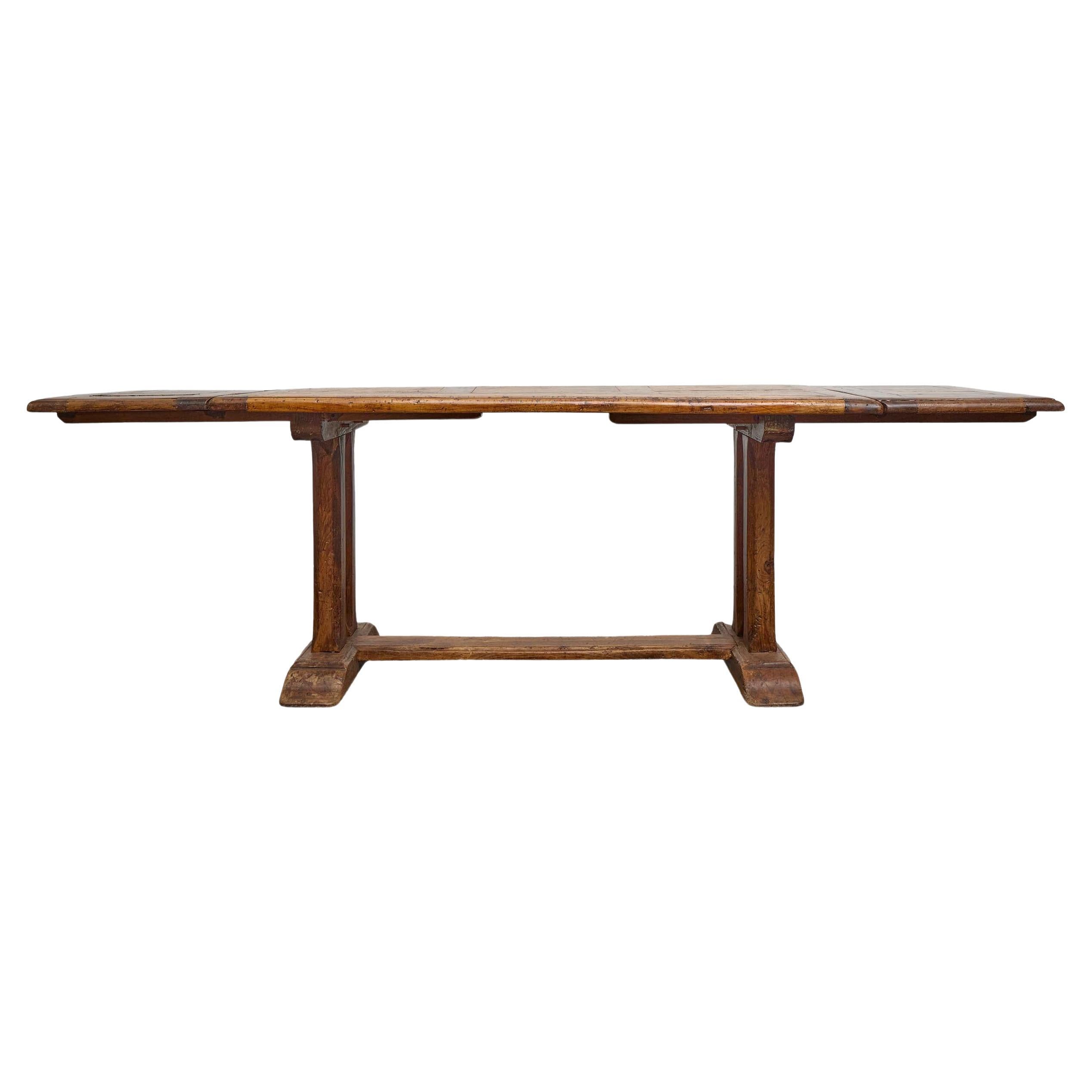 Une table de salle à manger en bois fruitier français massif du XIXe siècle, au caractère provincial classique et dotée d'un système d'extension pratique. Les proportions sont simples et honnêtes : un plateau de 62 pouces construit à partir