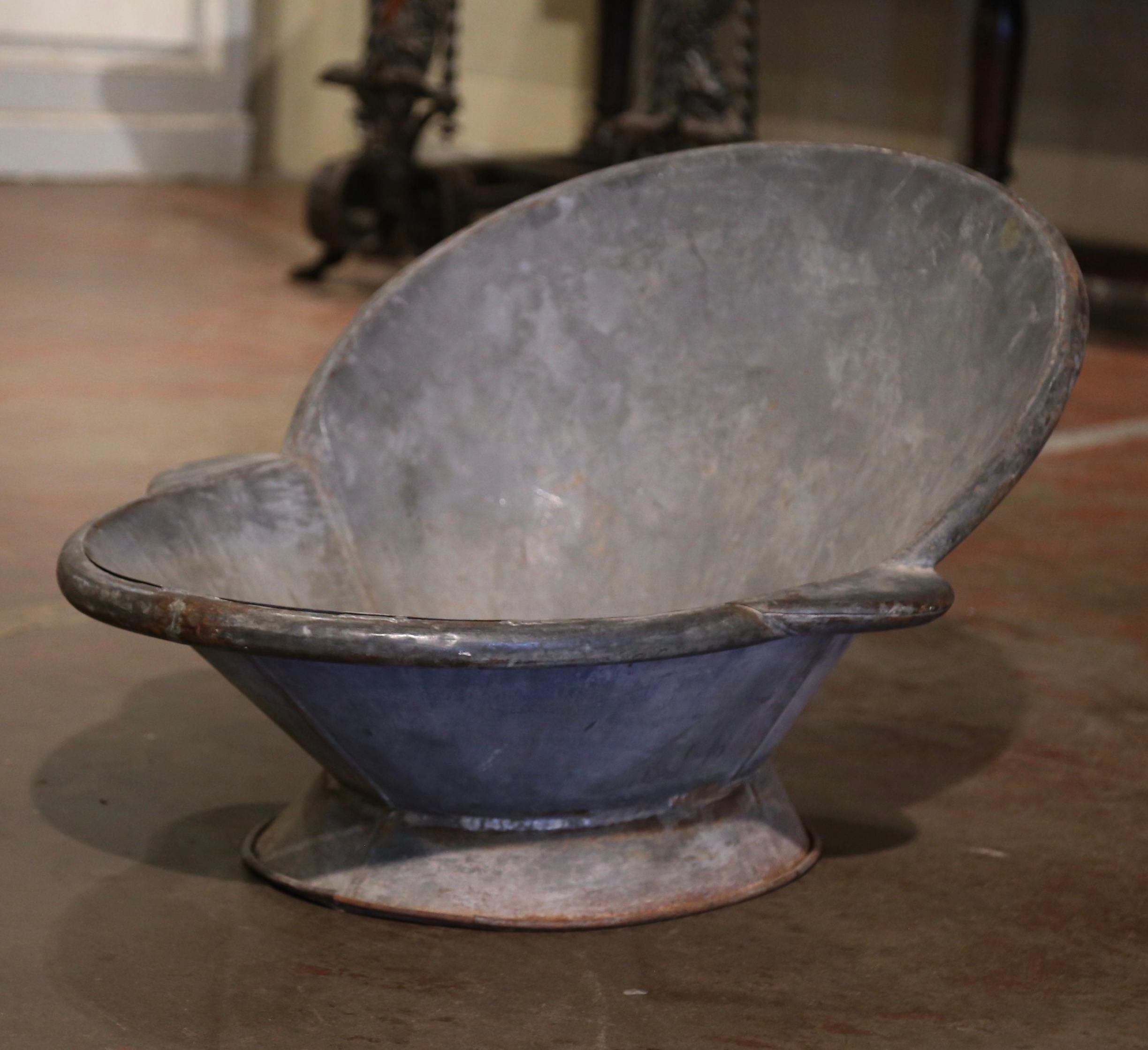 Use this decorative antique wash tub as a jardinière or a drink cooler! Crafted in France, circa 1880, the oval shaped baby bathtub features two sturdy metal grips on either side and roll edges around the rim. The solid tub is in good condition