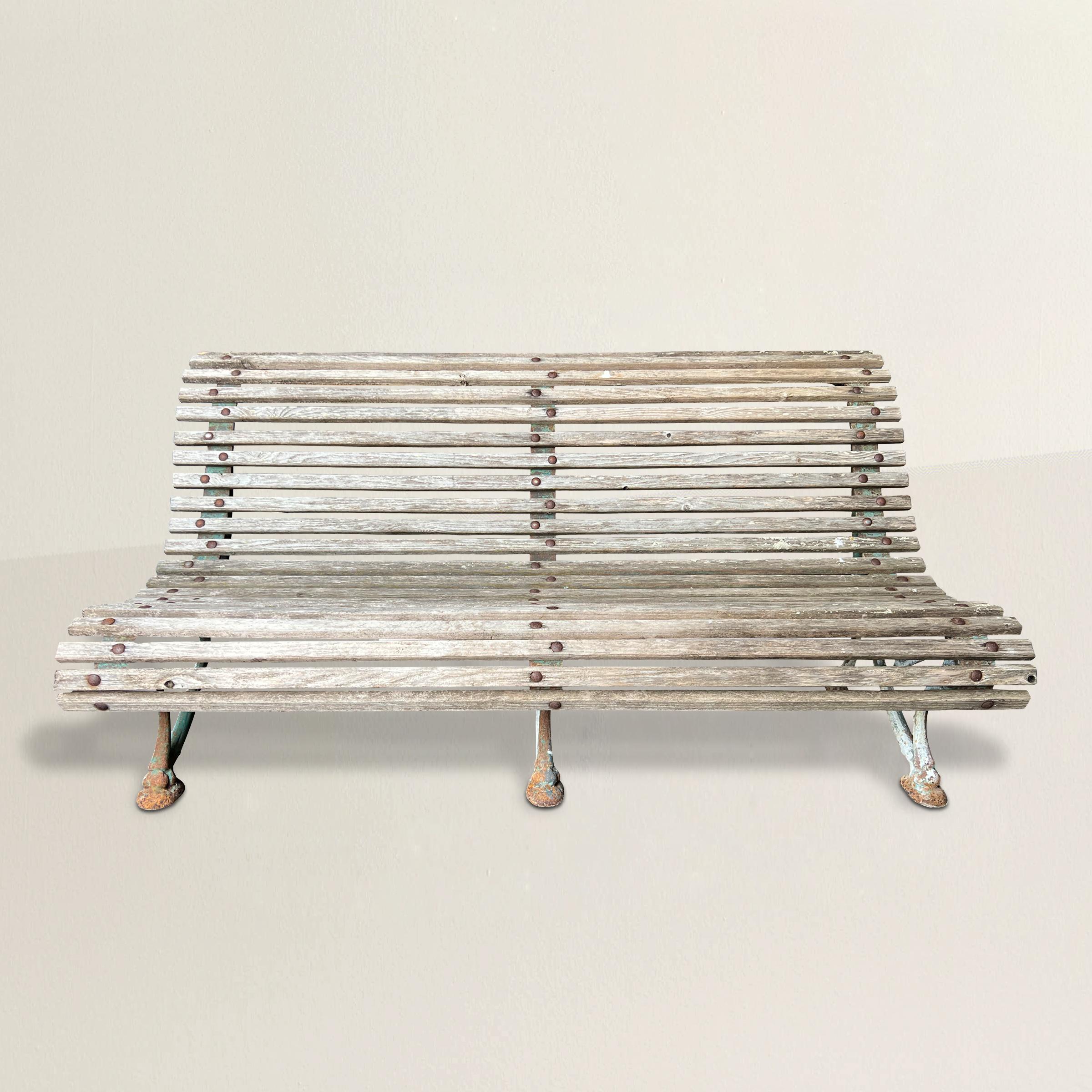 A spirited and playful late 19th century French cast iron garden bench with three scrolled legs and two dozen wood slats. The perfect perch to watch the flowers grow.