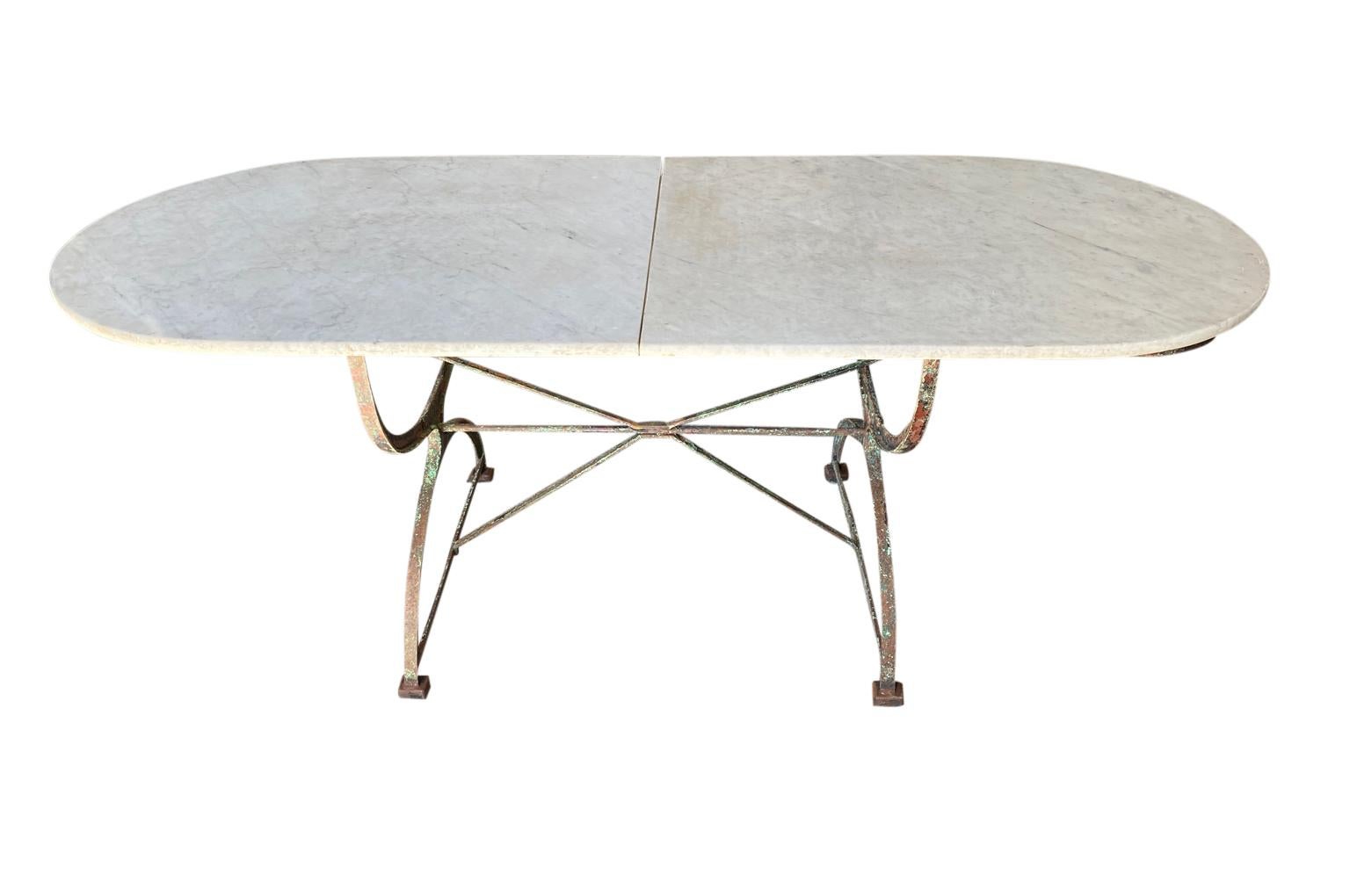 An outstanding and very beautiful 19th century oval shaped Garden Dining Table from the Provence region of France. Fabulous patina. Soundly constructed with a painted iron base and a marble top in 2 sections. Perfect for any interior of garden.