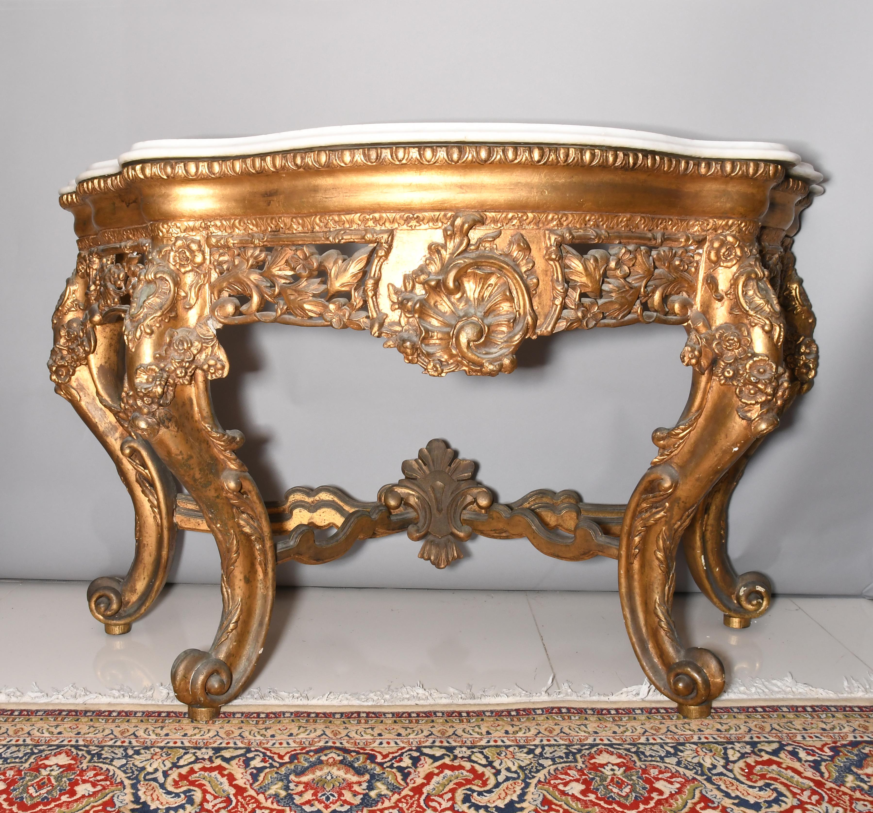 French console has festoon with leaves, flowers, and shells; plus highly scrolled feet and cabriole legs. The stretchers are joined In the center by a shield cartouche. The border of the top of the console is ornated with ribbed wood below a