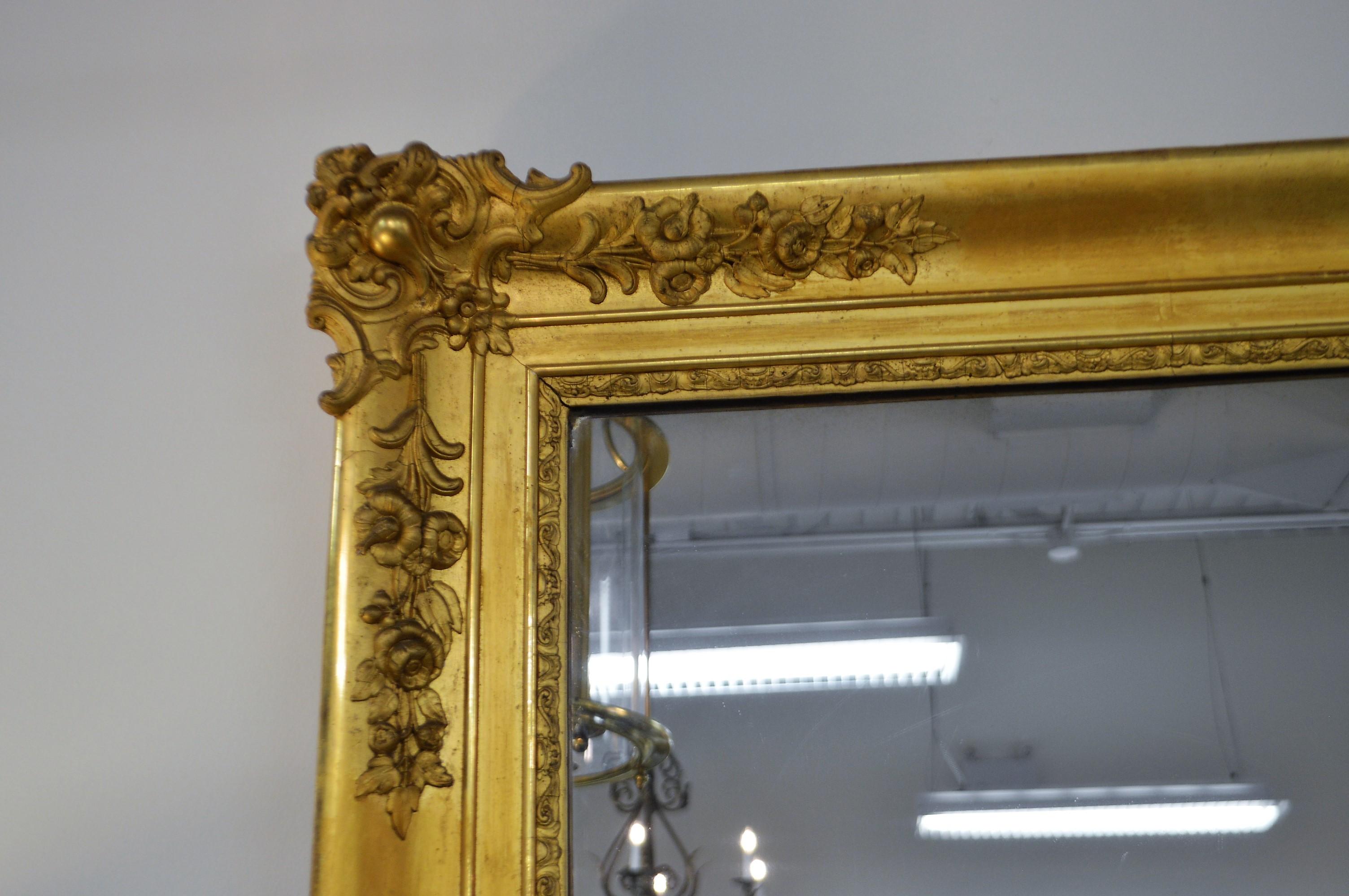 Excellent patina on this leaf gilded 19th century mirror from France. Hand carved details of crest with cascading of floral elements from all four corners.
The mirror is probably not the original one but it is in good condition.