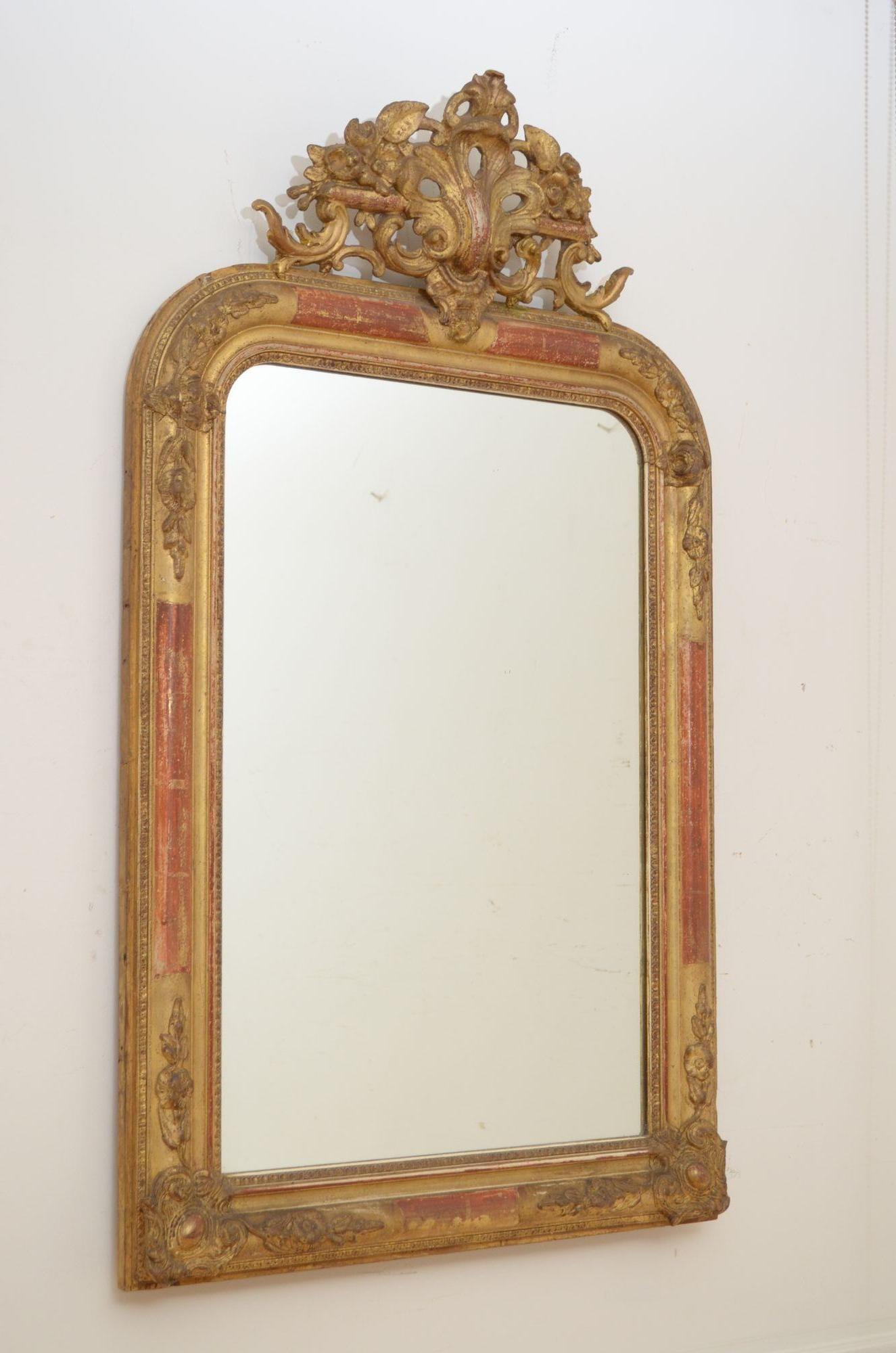 P0102 Fine XXth century French giltwood wall mirror, having original mirror plate with minor imperfections is gilded and moulded gesso frame with decorative floral corners to the top and bottom and elaborate pierced crest with carved flowers and
