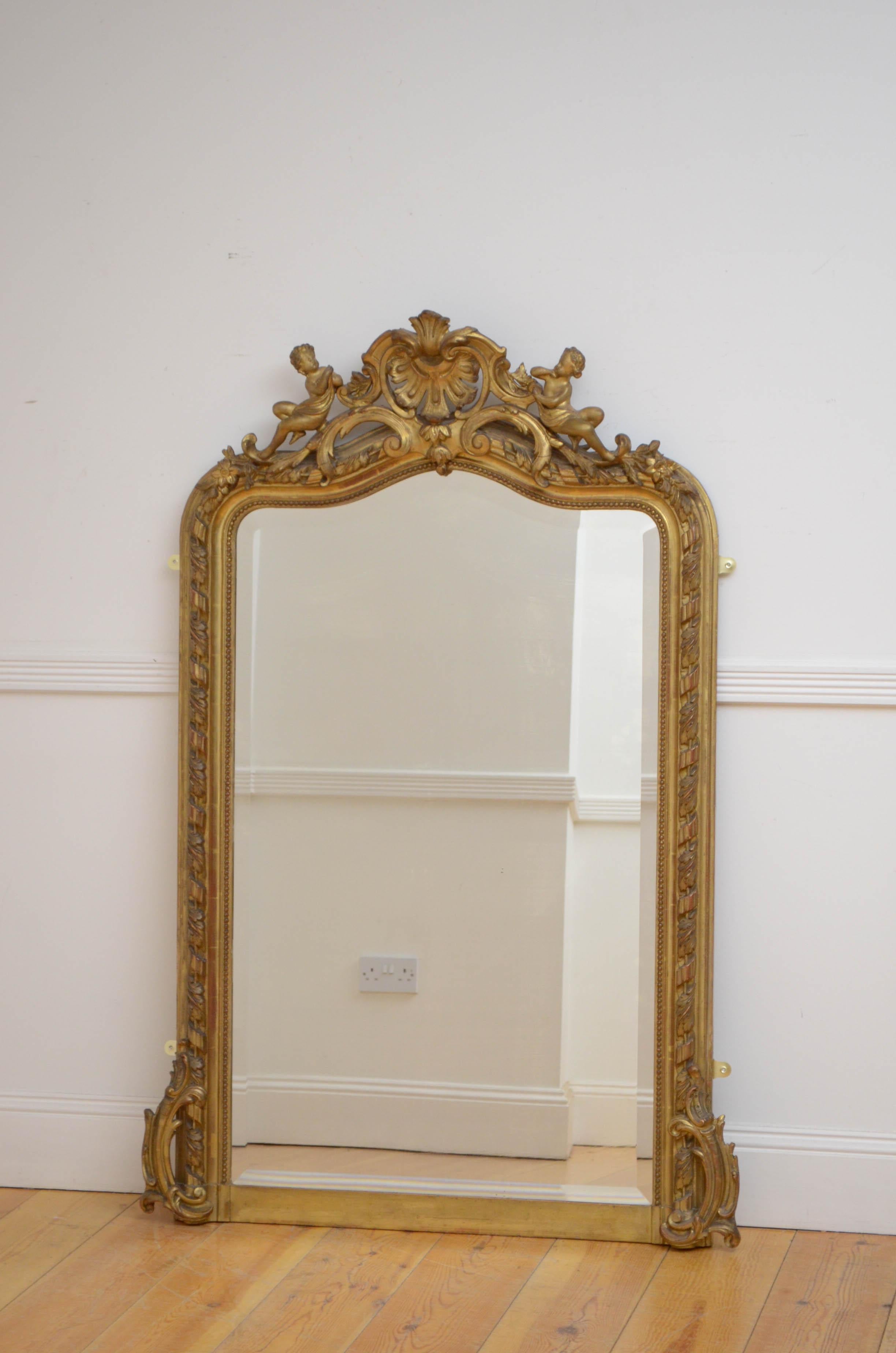 Sn5066 Attractive XIXth century giltwood wall mirror, having original bevelled edge glass with some imperfections in finely carved frame with leafy scrolls to base and elaborate crest with cherubs to the top. This antique mirror retains its original