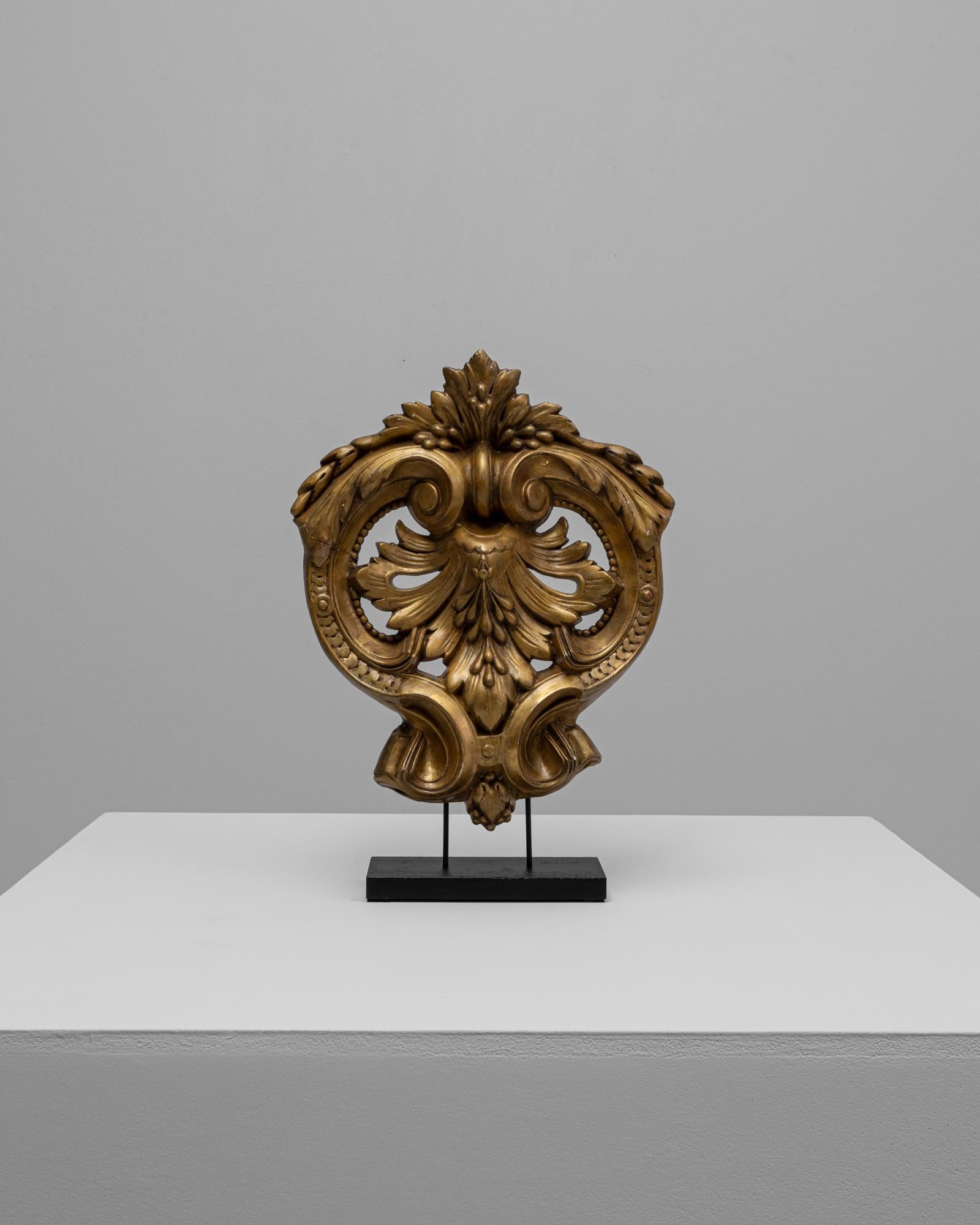 Questa decorazione in legno dorato francese del XIX secolo mette in mostra la raffinata abilità artistica e l'estro ornamentale caratteristici dell'epoca. Scolpito con intricate volute, foglie d'acanto e motivi fogliacei simmetrici, il pezzo mostra