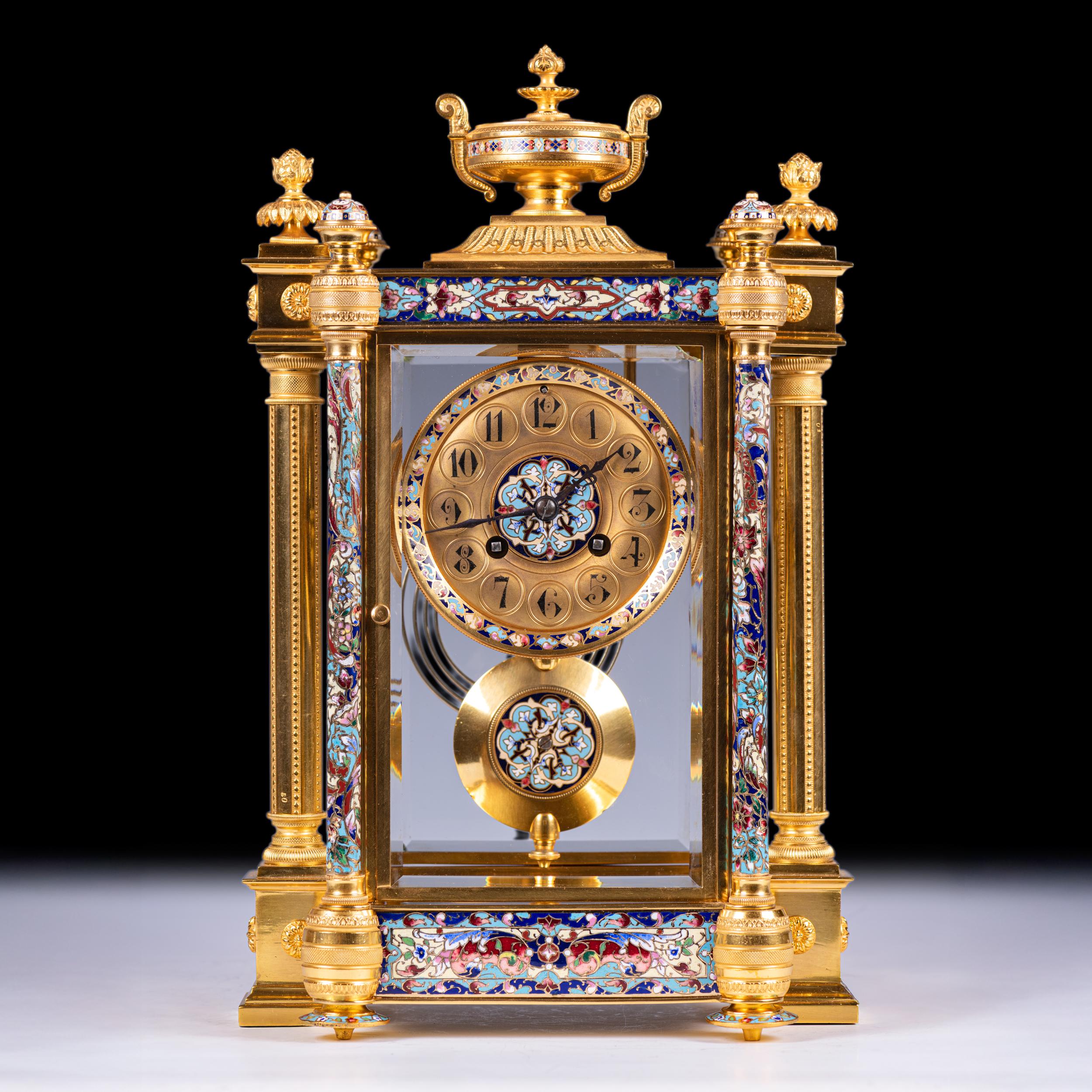 Superbe pendule de cheminée à quatre verres en bronze doré et émail champlevé du XIXe siècle. D'une qualité exceptionnelle, cette pendule de cheminée à quatre verres richement ornée est logée dans un boîtier en bronze doré finement coulé, décoré de