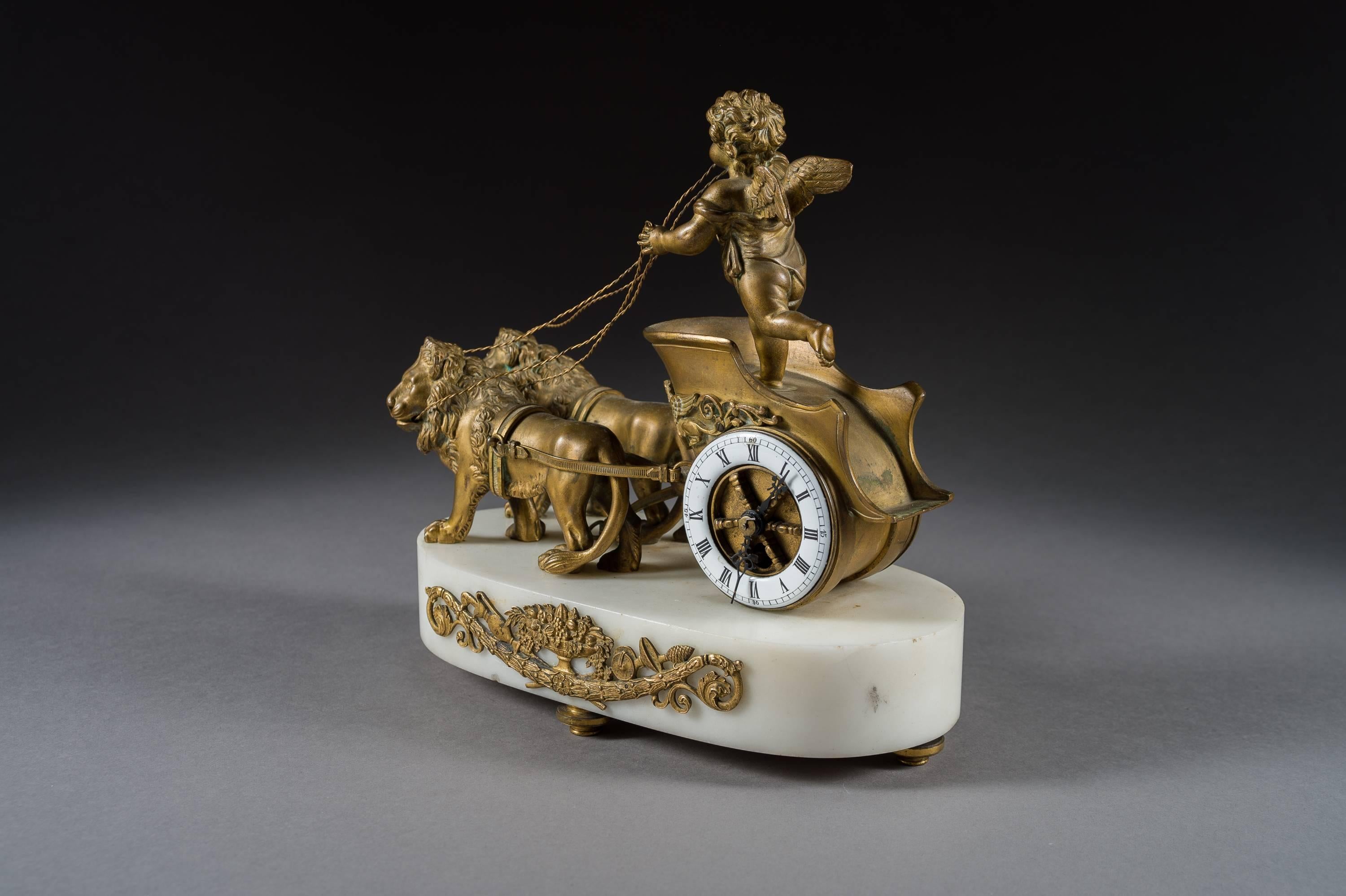 19th century French gilt bronze and marble desk clock 

France, circa 1890.

Decorated with a standing bronze putti on a chariot with two lions, on a white marble base with attached ormolu mounts under a white enamel dial with roman