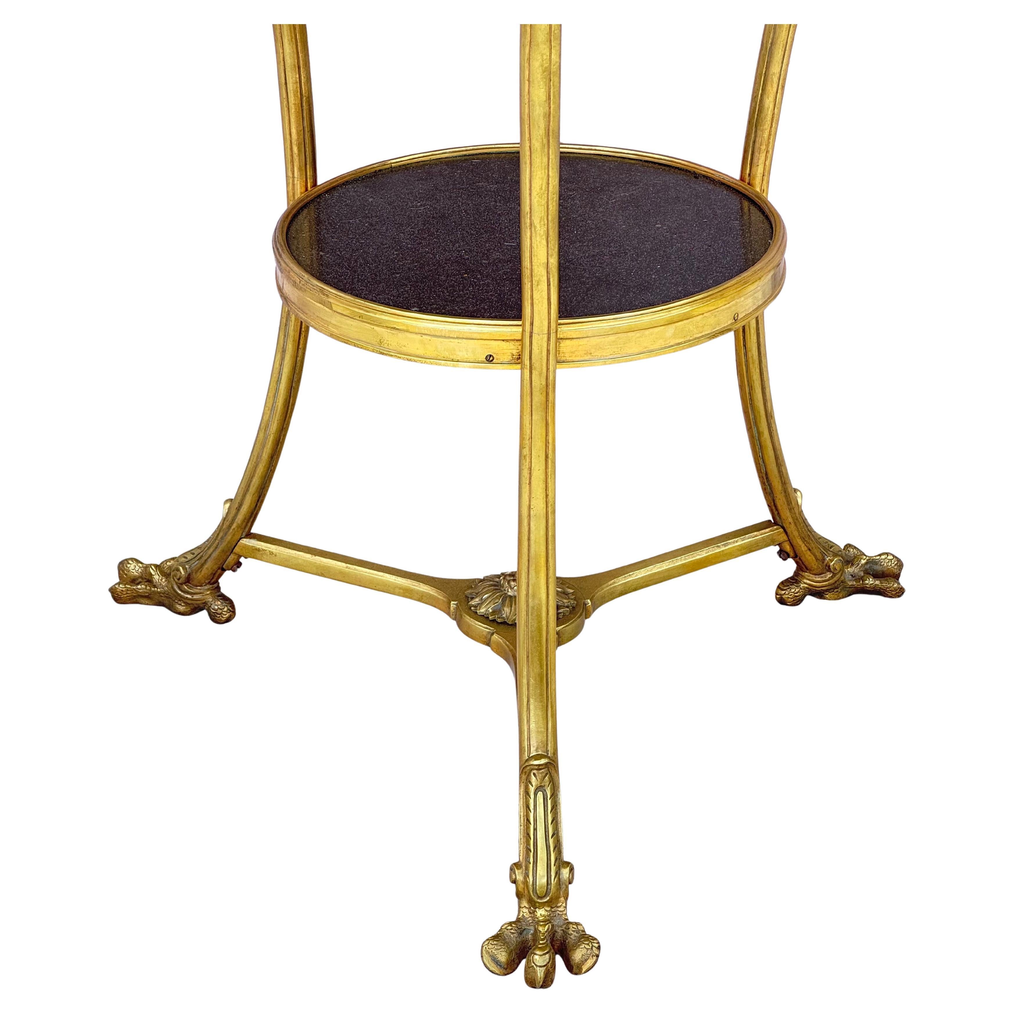 Fin du 19e siècle Français doré  Table Guéridon en bronze et marbre. Cette table remarquable présente des garnitures décoratives en bronze ainsi que des pieds en bronze doré ornés de poignées en forme d'anneau d'aigle et de pieds en talon en bronze.