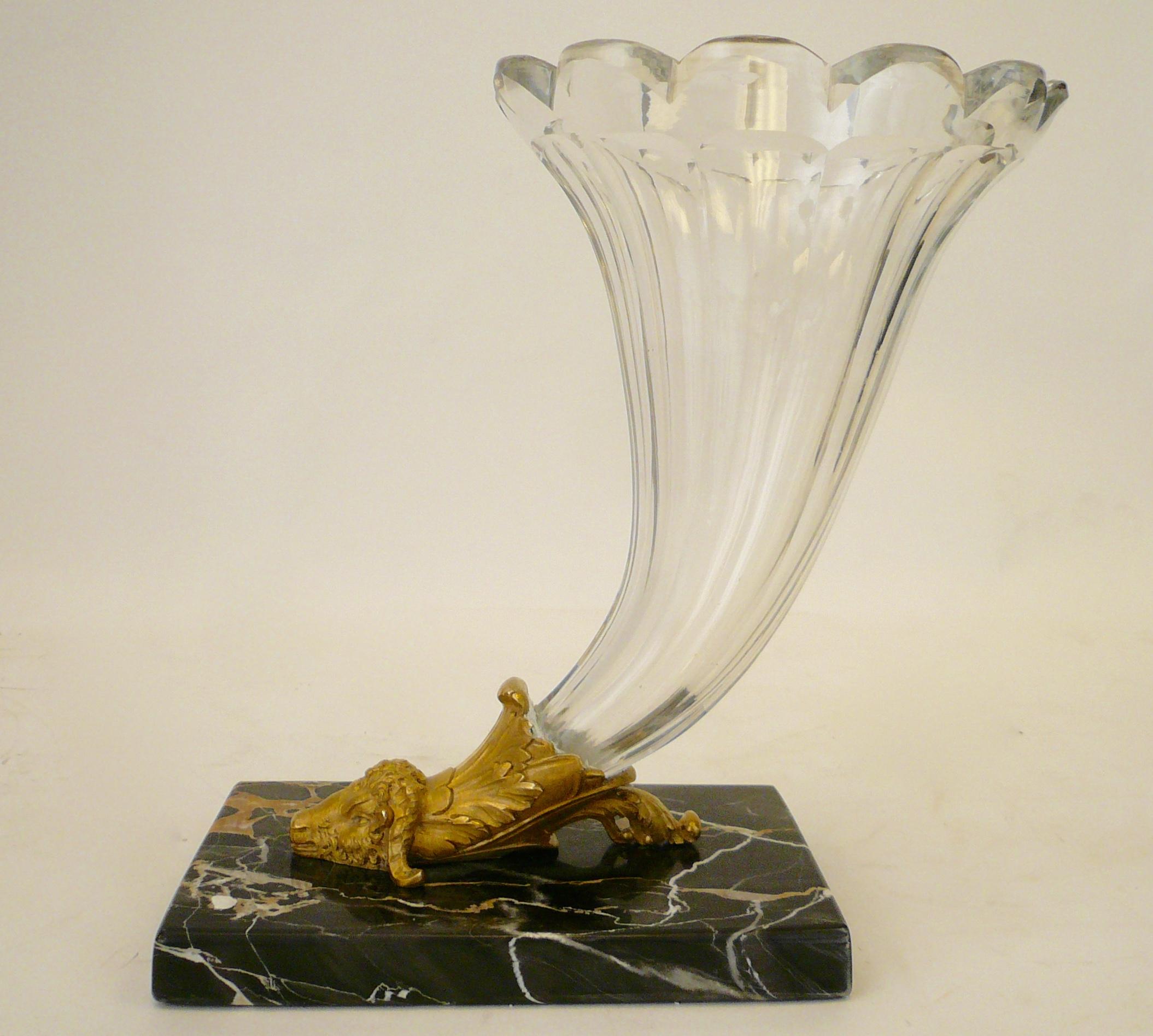 Questo grande vaso a cornucopia in cristallo tagliato termina con una montatura in bronzo dorato a forma di testa di ariete e poggia su una base in marmo nero.