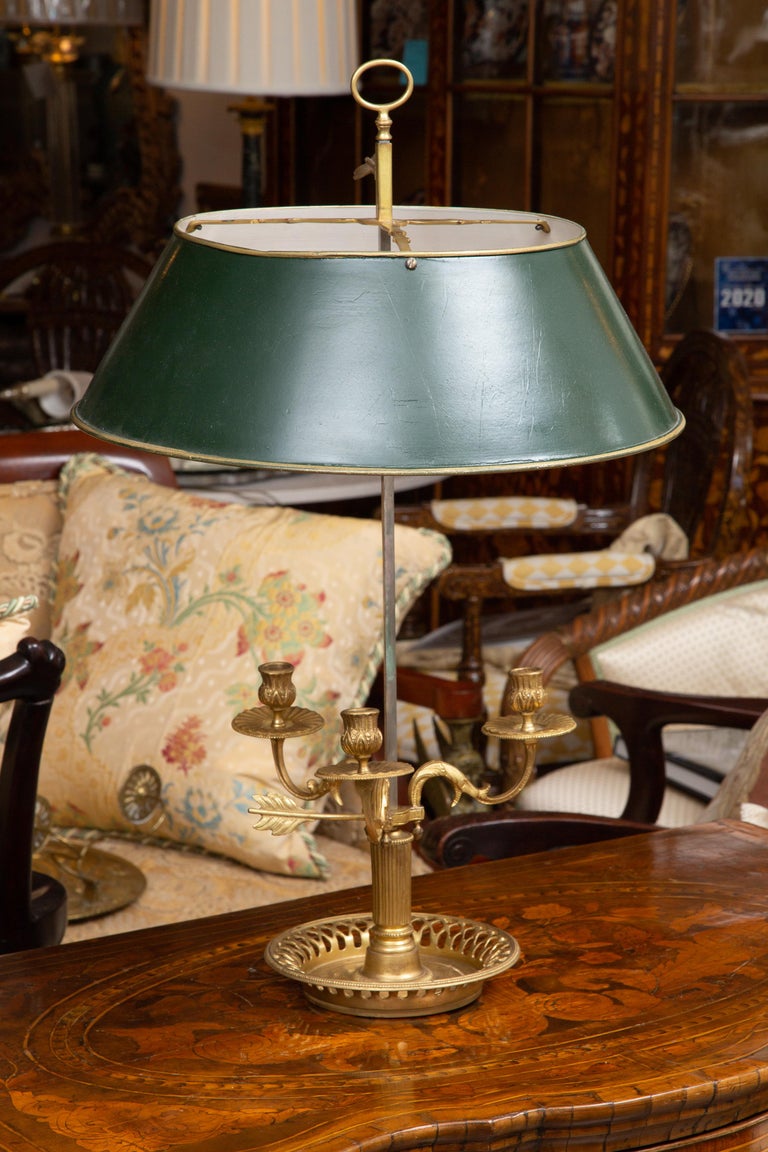 These are stately and identical classic gilt bronze bouillotte lamps with green painted tole shades, 19th century. Sold Individually. Pair available.