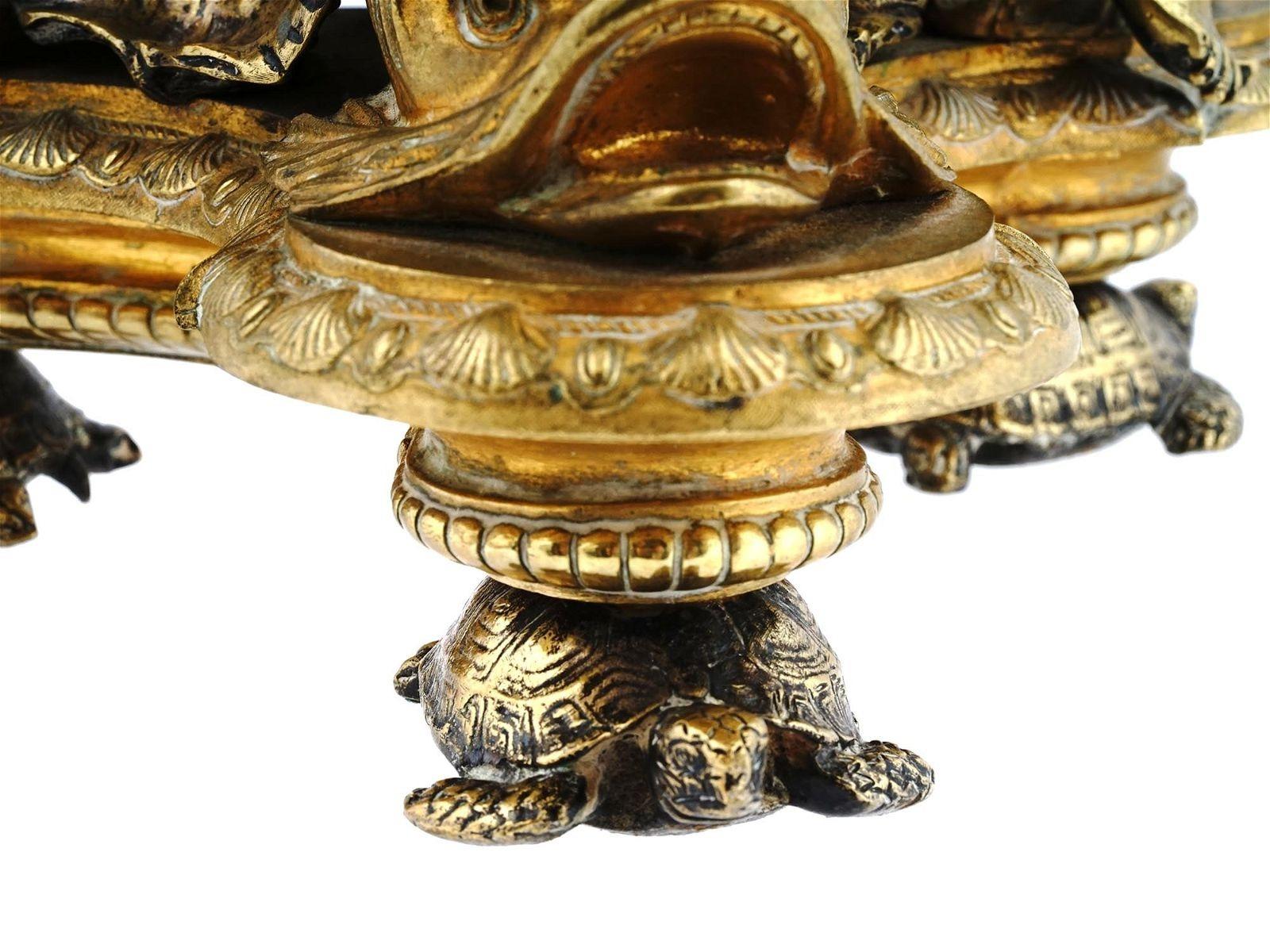Exceptional antique (19th century) French gilt bronze centerpiece in the neoclassical Baroque style, with shaped bowl with neoclassical figures in a central cartouche inside and bas-relief designs on the outside, supported by three putti resting on