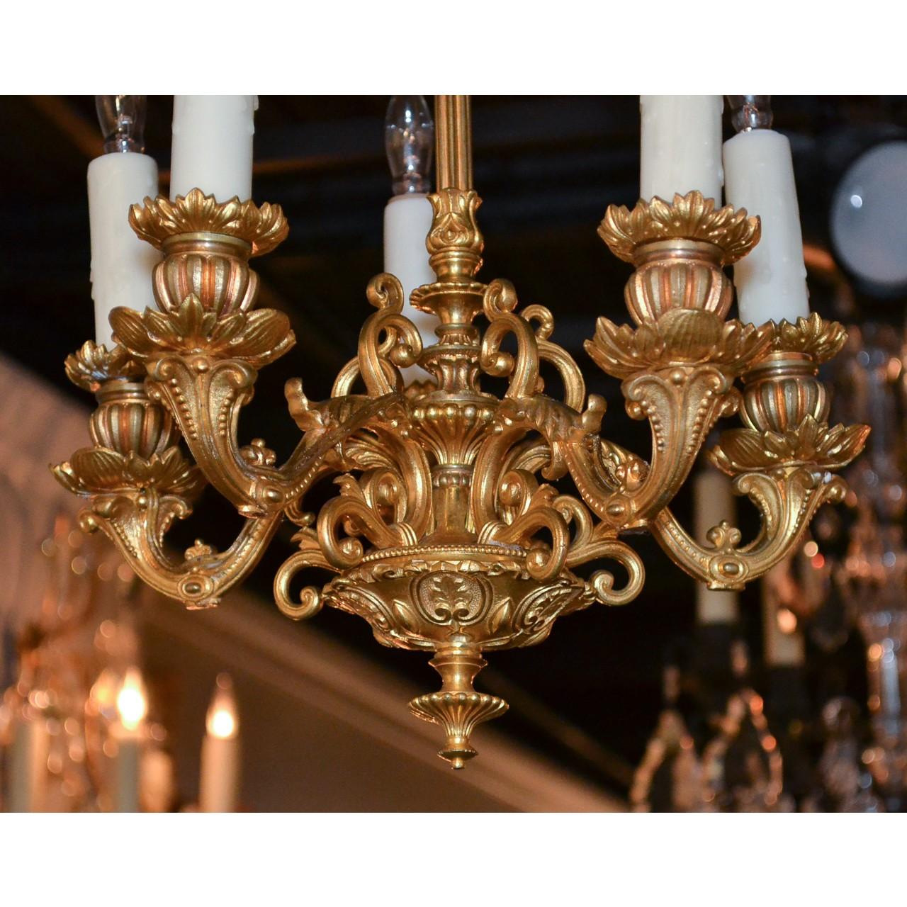 Elegant small scale 19th century French gilt bronze chandelier with a repousse decorated canopy atop an foliate motif stem and open-work cage. The gracefully scrolled horn-shaped arms with flower petal bobeches having urn and acanthus leaf styled