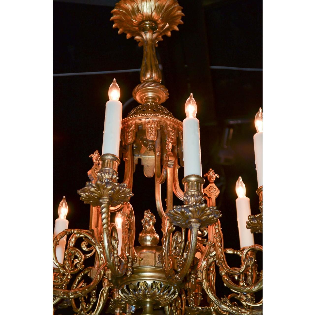 Exceptional 19th century French gilt bronze chandelier. The flared leaf spray canopy atop a shaped stem, pierced crown, and flame finial. Mounted with ten elaborately scrolled arms having foliate motif bobeche and fluted candle cups. The base