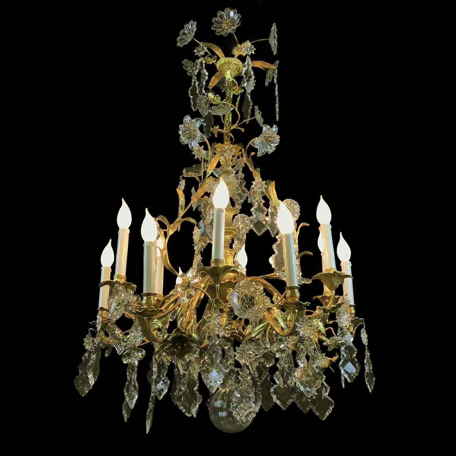 Exceptional fire gilt bronze and crystal chandelier of French origin, a two tier twelve-light hanging fixture dating back to circa 1870 born for candle burning, modified to electric, with a unique ormolu branches and flowers frame, richly adorned by