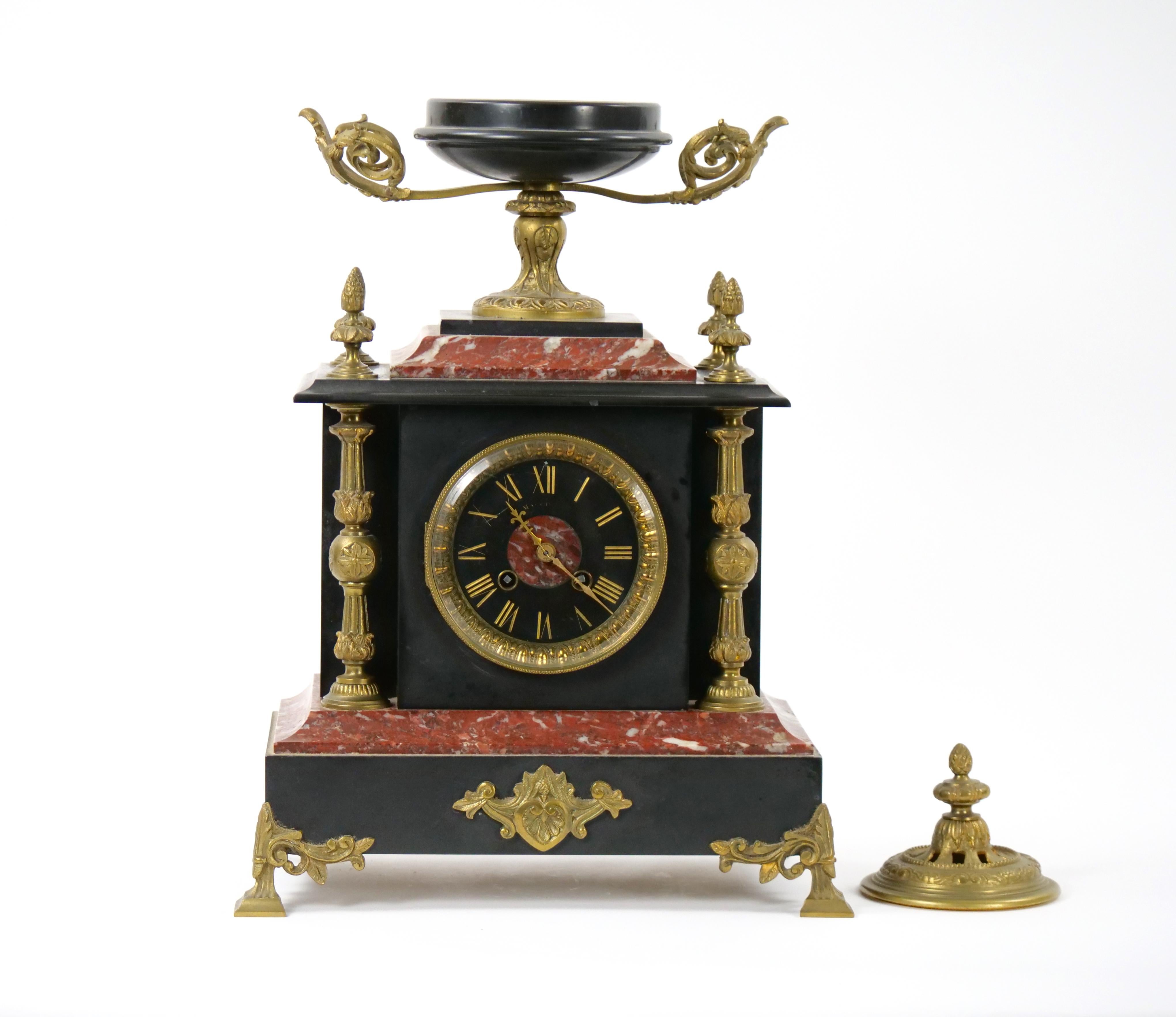
Transport yourself to the elegance of the 19th century with this exquisite French Gilt Bronze-Mounted Slate and Rouge Marble Mantel Clock. Meticulously crafted, this timepiece is a celebration of artistry, design, and precision. The fusion of gilt