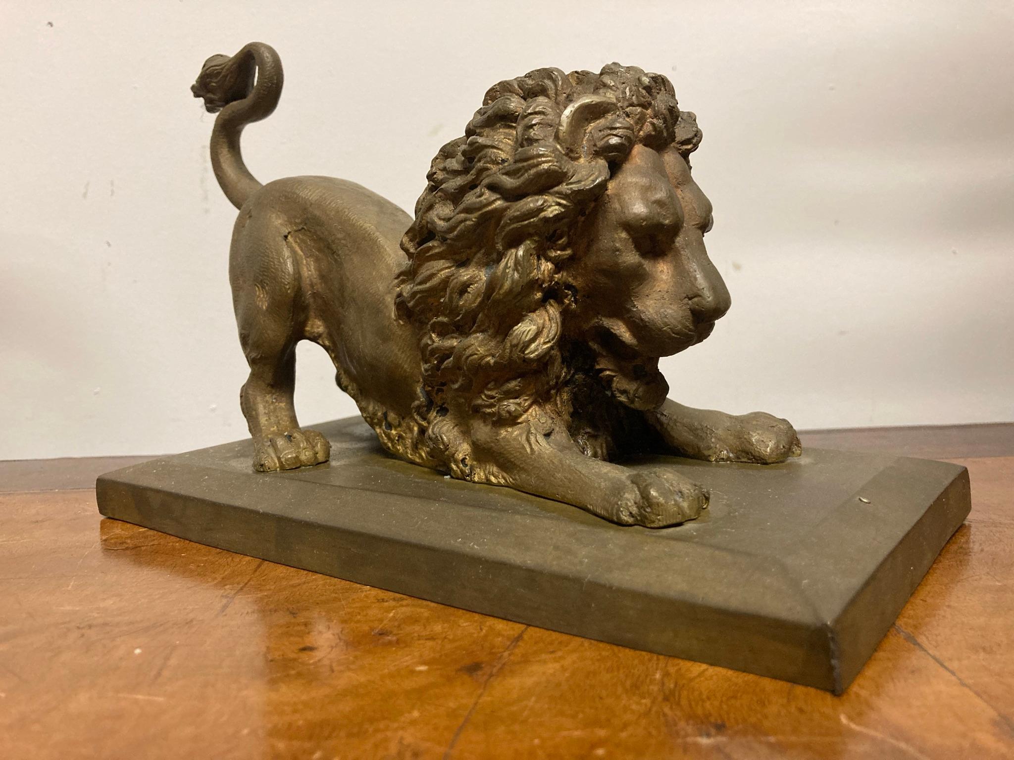 Gilt bronze crouching lion on integral rectangular base. Fine realistic cast showing the animated male lion in the act of poncing, or perhaps just having a nice stretch. The big cat is doing 'down dog'. Great gift for the yogi in your life!