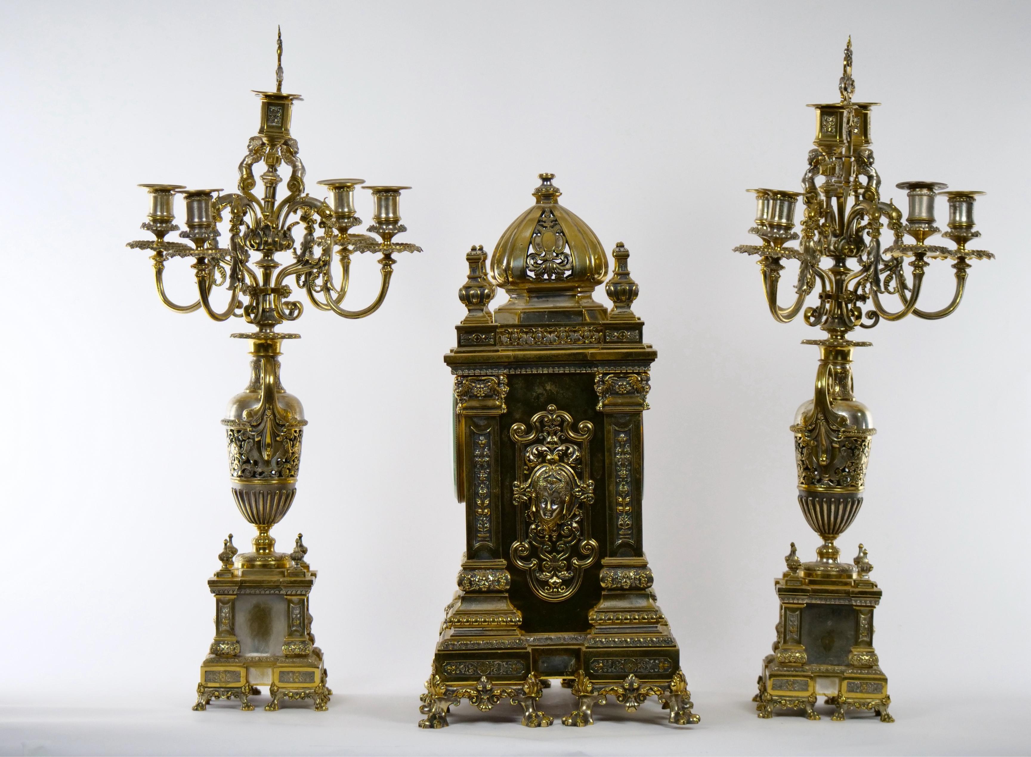 Great craftsmanship French gilt bronze and silvered brass three piece clock garniture from the mid 19th century. The set include a French ebauche clock 8-day brass time and strike movement. Signed by the maker's and dial marked by the retailer 