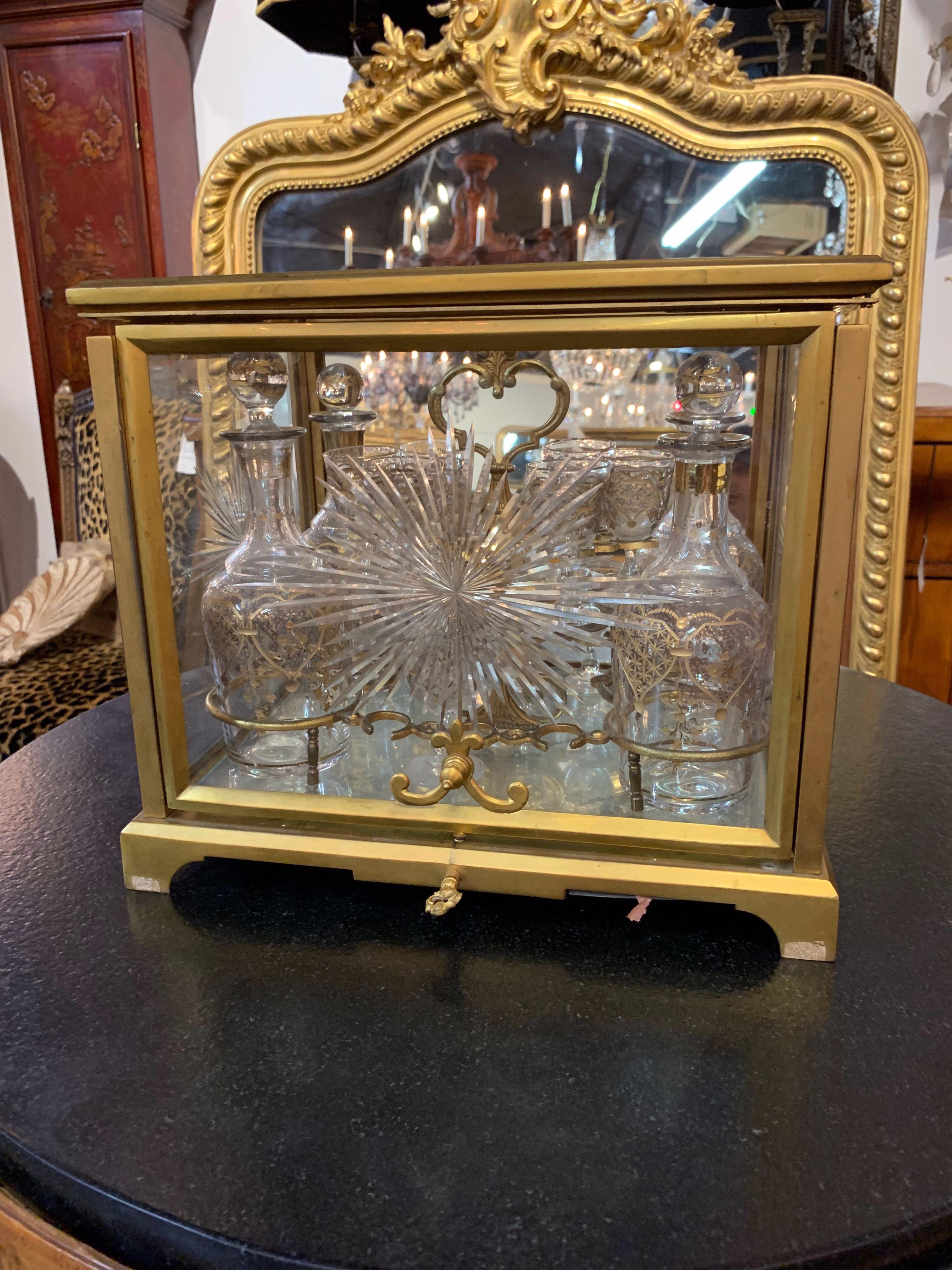 19th century French gilt bronze Tantalus that contains 10 cordial glasses and 4 decanters. Beautiful cabinet of gilt bronze and etched glass. The glasses and decanters are trimmed in gold. Very impressive set!, circa 1880.