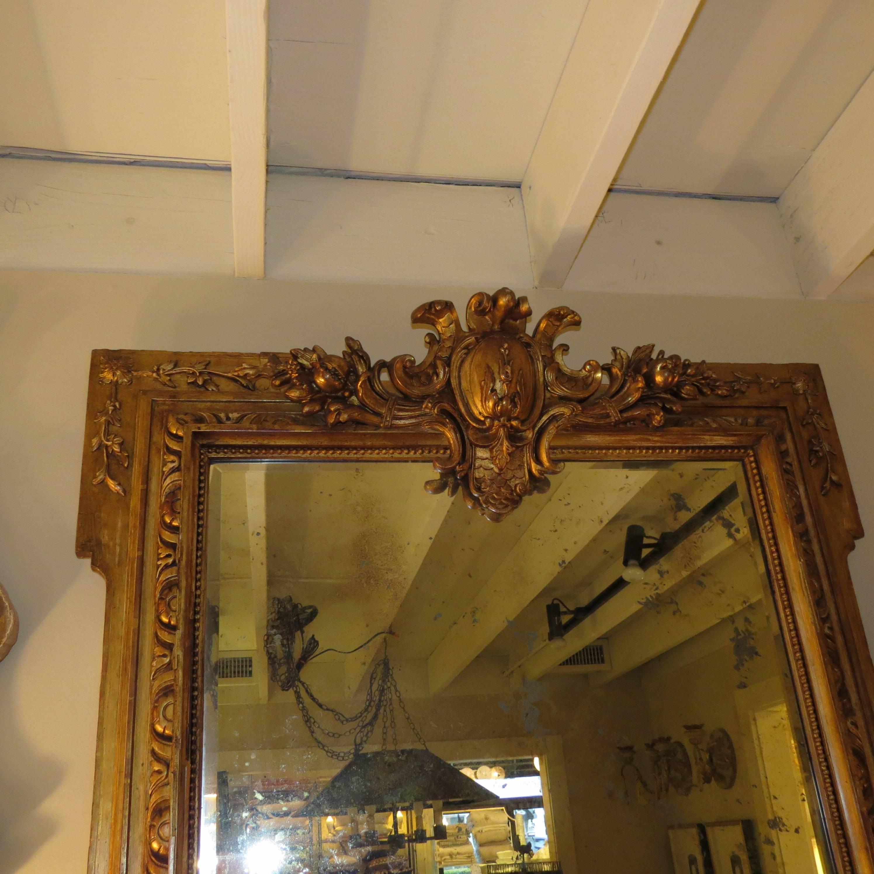 Ornate 19th century French, gilt frame hold a more recent, distressed mirror. Mirror is mottled on back side, no defects in front surface.