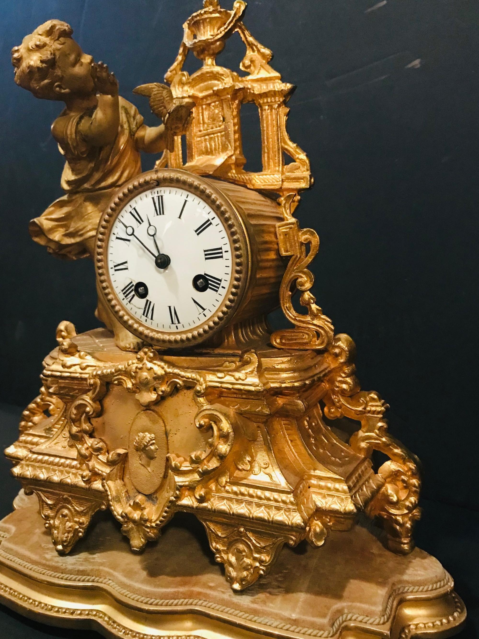 19th century French gilt mantel clock with wood base, girl with bird 

This Napoleon III ornate mantel (fireplace) clock has a great gilt finish. It was created in France in the late 19th century. The clock sits on it's original velvet covered wood
