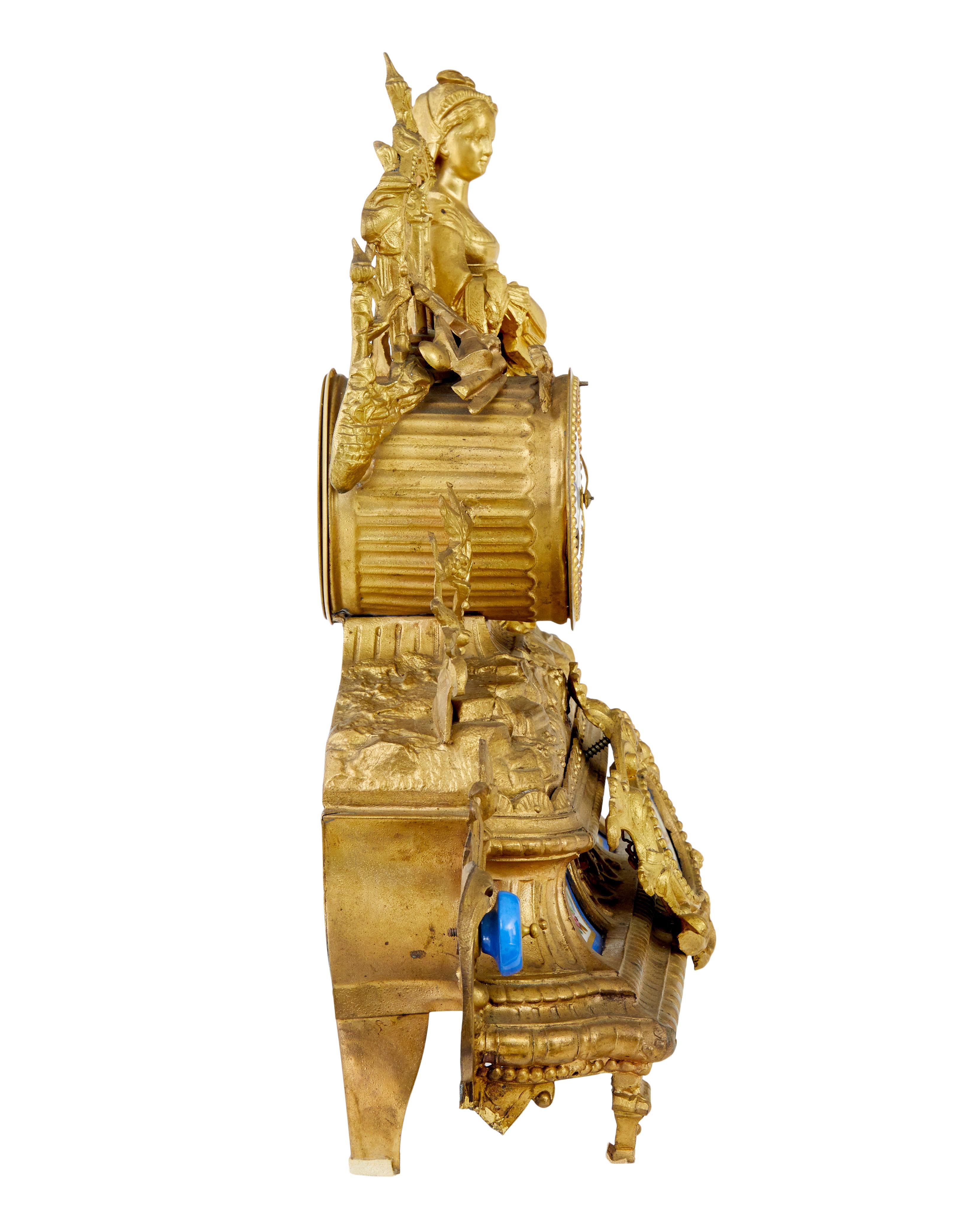 19th century French gilt mantle clock with sevres plaques circa 1890.

Fine quality ornate french clock surmounted with a lady in traditional french dress leaning on an architectural window and ship building tools.  Enamel clock face with roman
