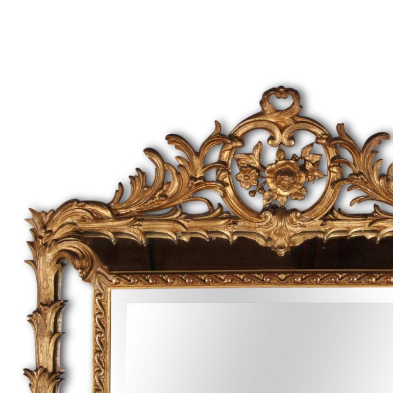 A lavishly carved and gilt-framed French 19th century mirror, with a faceted mirror frame featuring acanthus leaf detailing to the sides and an ornate pierce-carved crown, circa 1875.



 