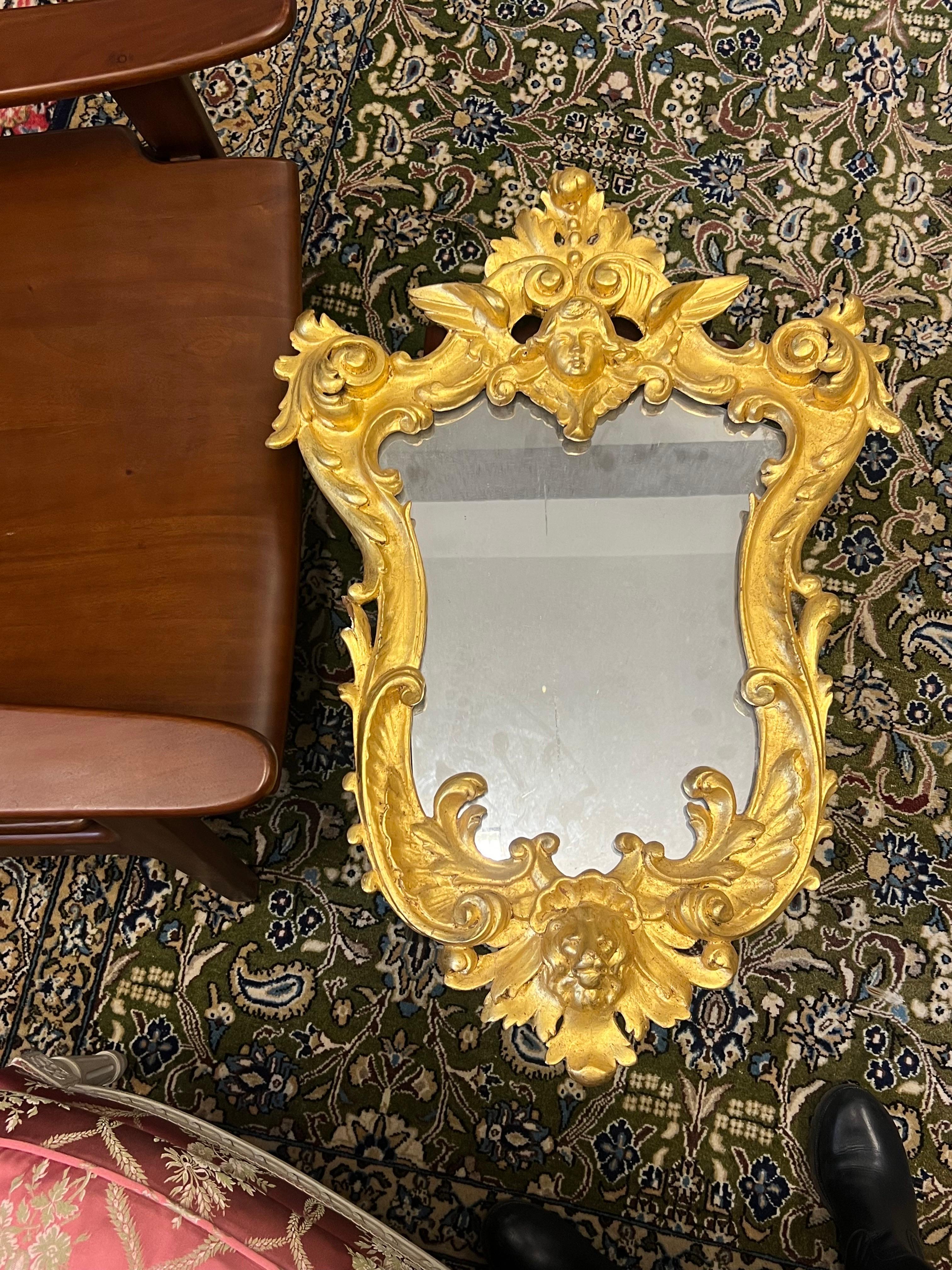 19th Century French gilt wood hand carved wall mirror in Louis XV style decorated with an angel and a lion head. Original condition without restaurations.
France, circa 1880
