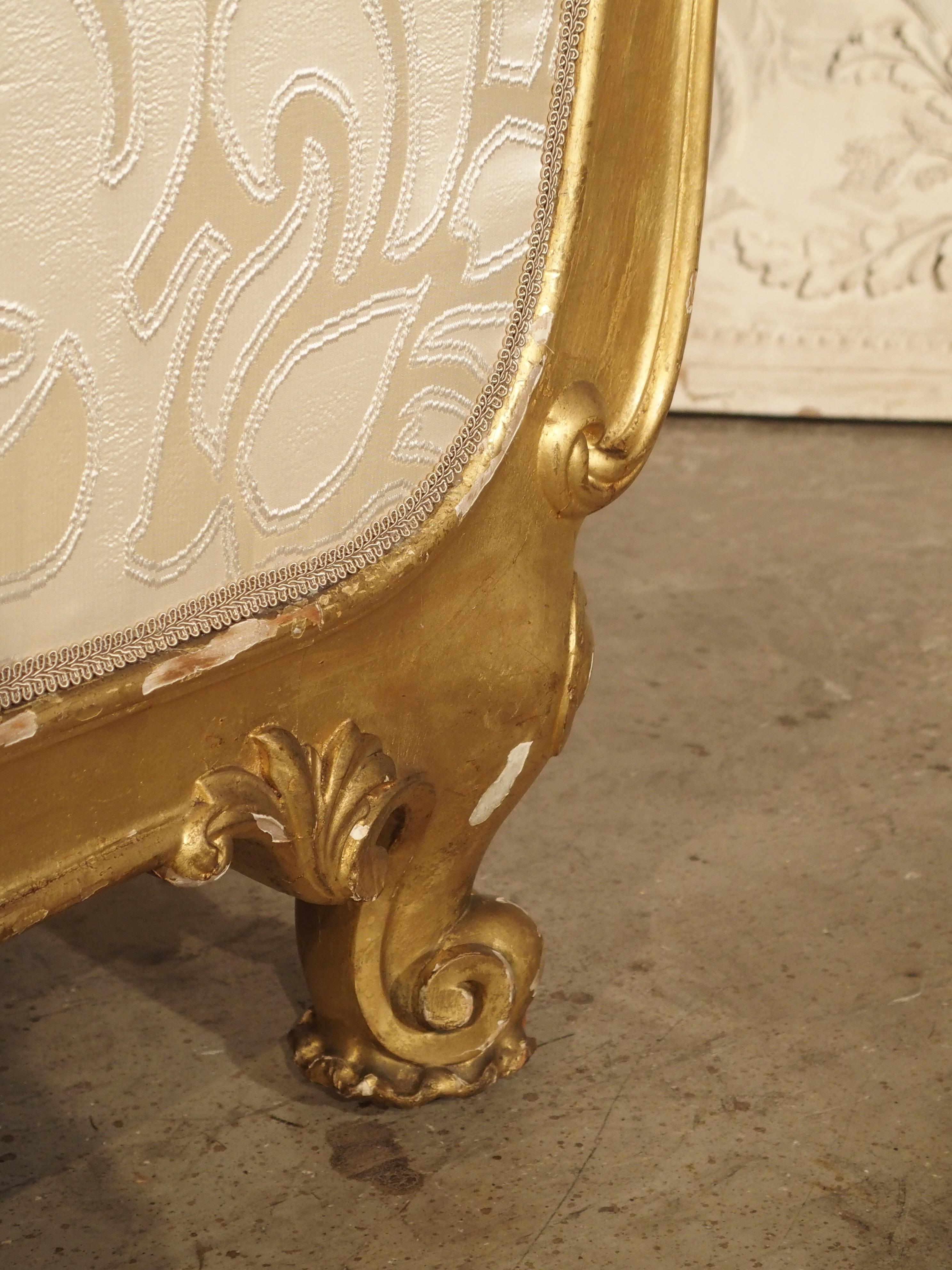 From the late 1800s, the graceful yet substantial French, giltwood chaise lounges in the Louis XV style. The long cushion, frame, and pillow have been re-upholstered in a beautiful Italian Bergamo silk. The frame of the chaise is carved giltwood