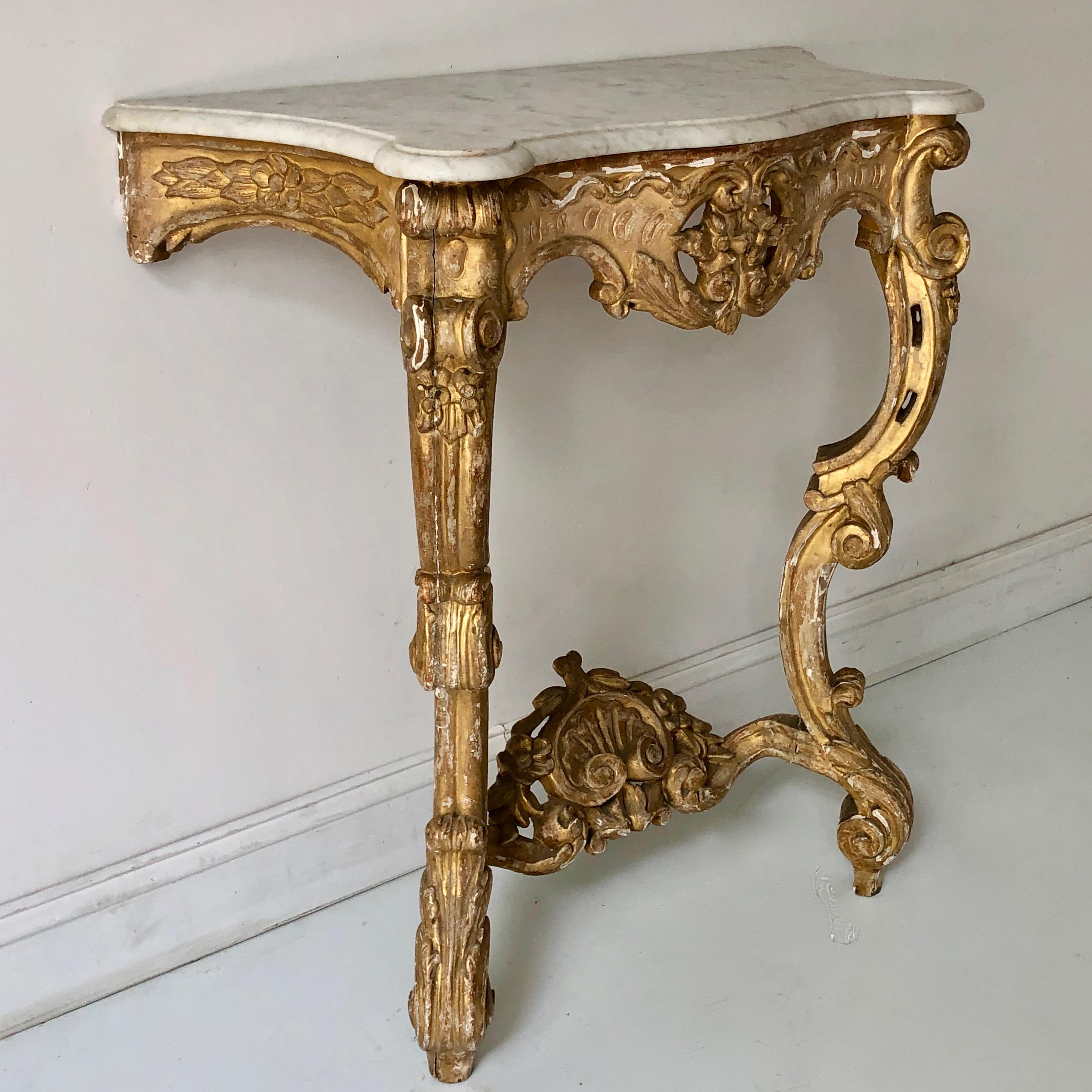 19th century French giltwood console table with open work cartridge and shaped white marble top raised on ritchy carved cabriole legs.

