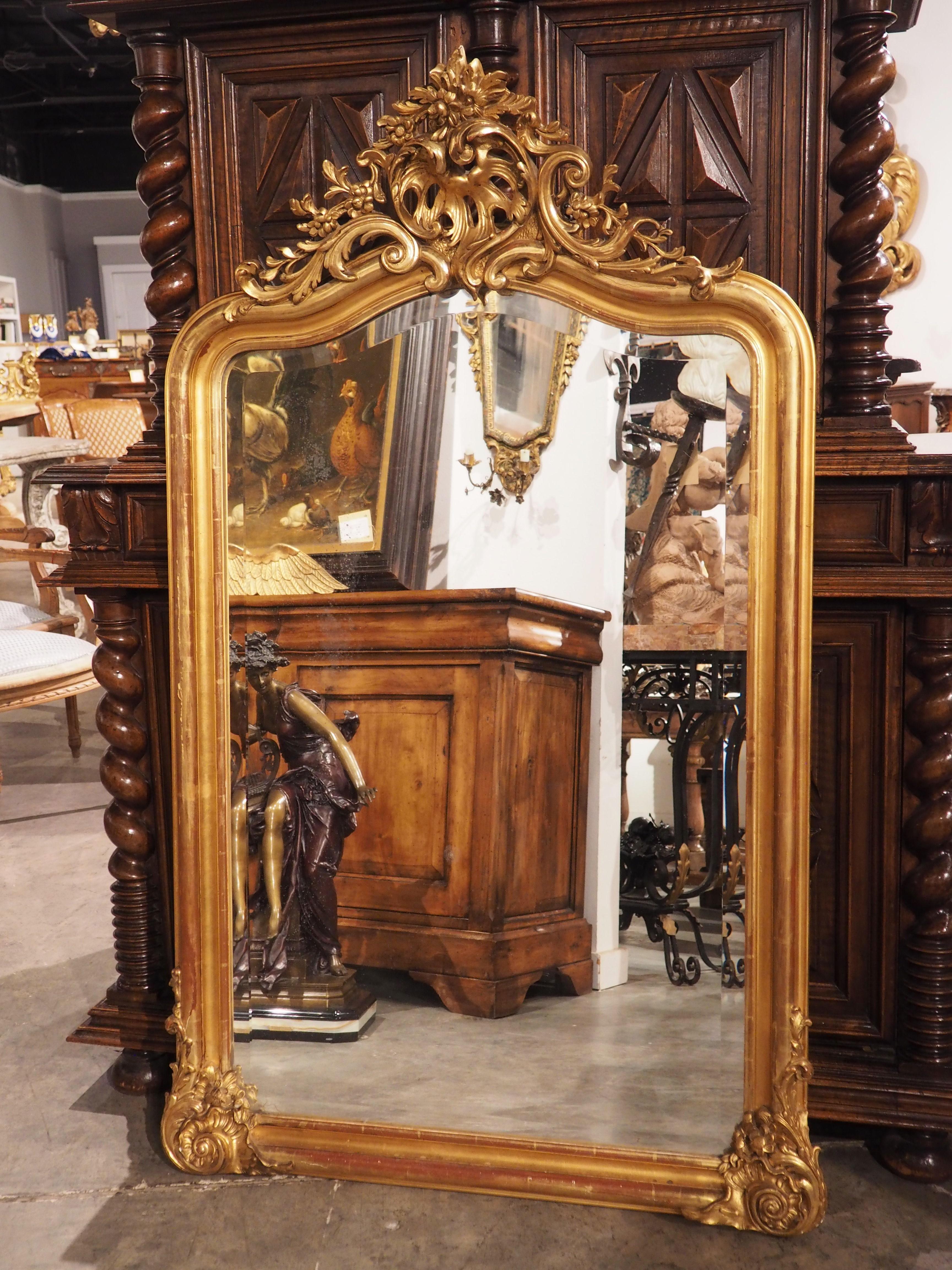 A highly elaborate style of décor that developed under the reign of Louis XV (1715-1774), the Rococo style is identified by its lively elements inspired by nature. This French giltwood beveled mirror, hand-carved circa 1875, possesses such features,