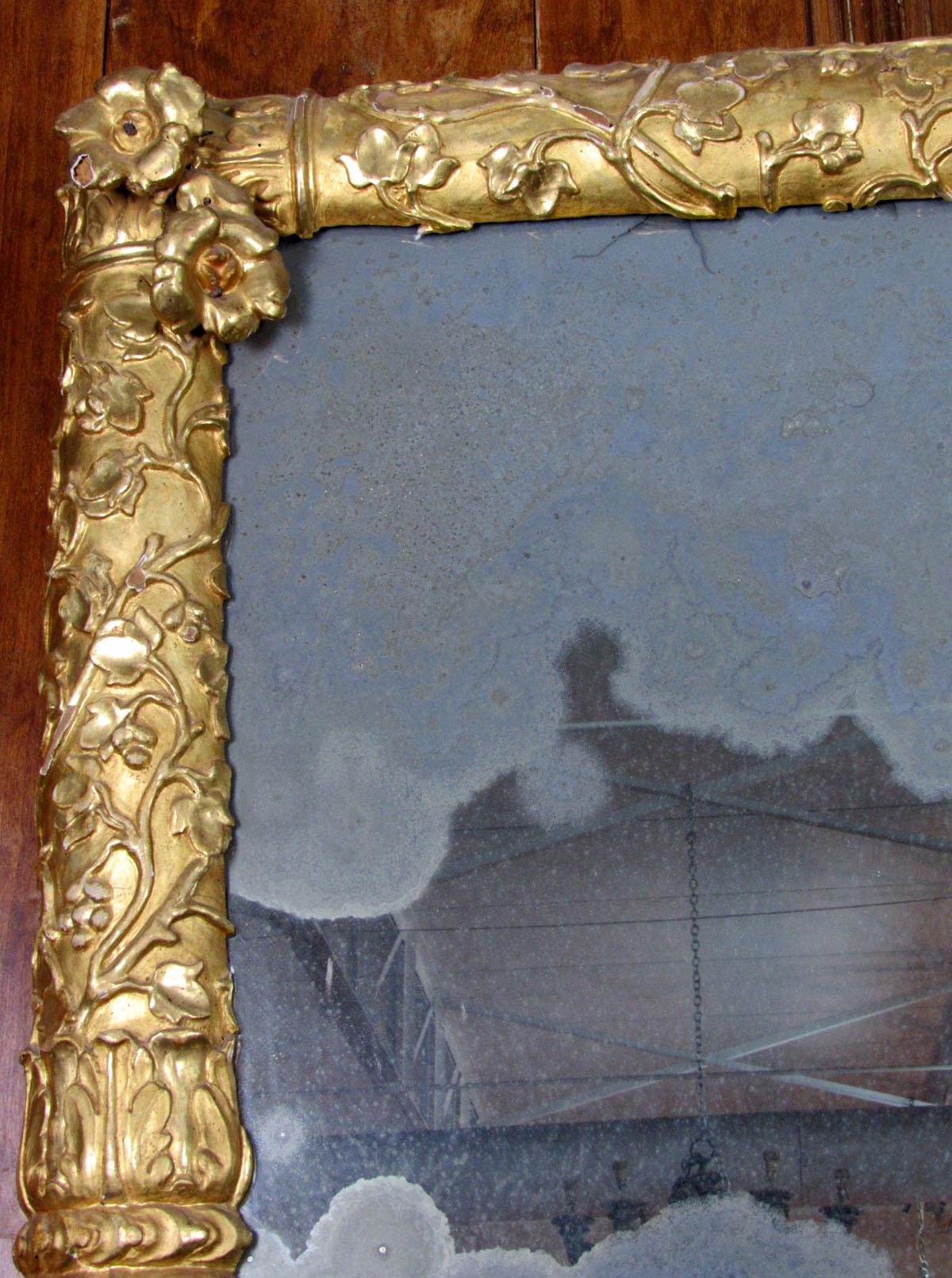 French Restauration period carved giltwood frame with modern antiqued glass.