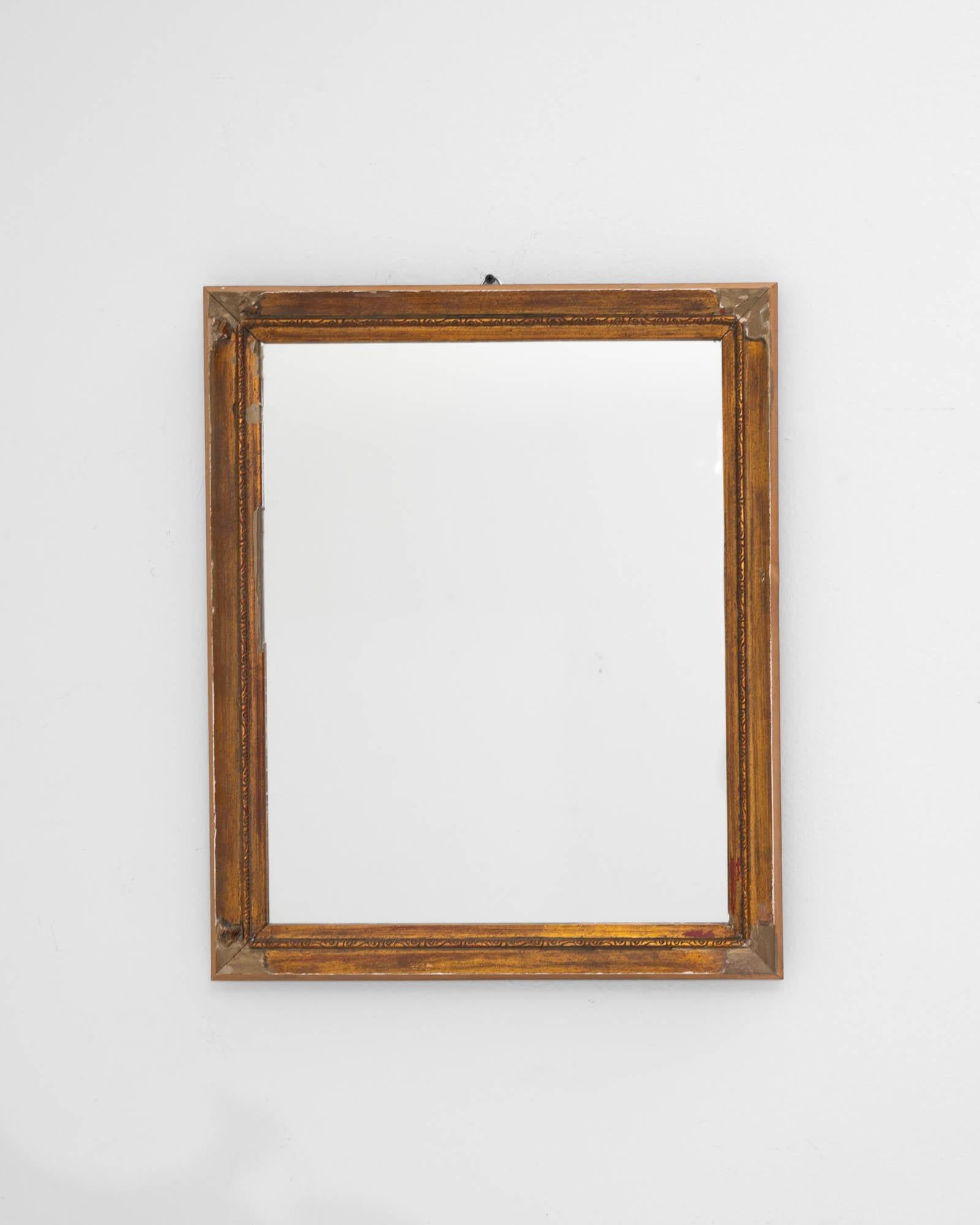 A wooden gilded mirror created in 19th century France. With rustic yet elegant patterned wood and an attractively shaped frame, this mid-sized mirror offers a refined composition for reflection. The time-touched frame, mesmerizingly adorned with
