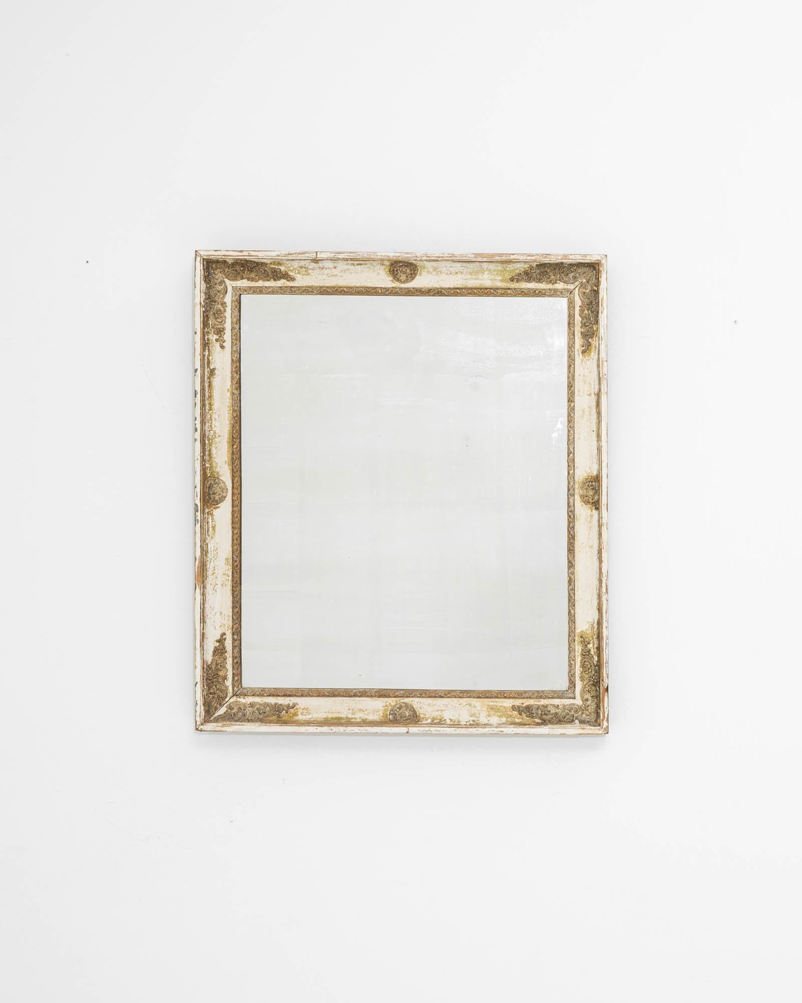 A wooden, gilded mirror created in 19th century France. The time-touched frame, mesmerizingly adorned with sculpted details, leads the eye around its edges. Gilded with age and posed quietly on the wall, this lovely mirror draws one nearer. Profiled