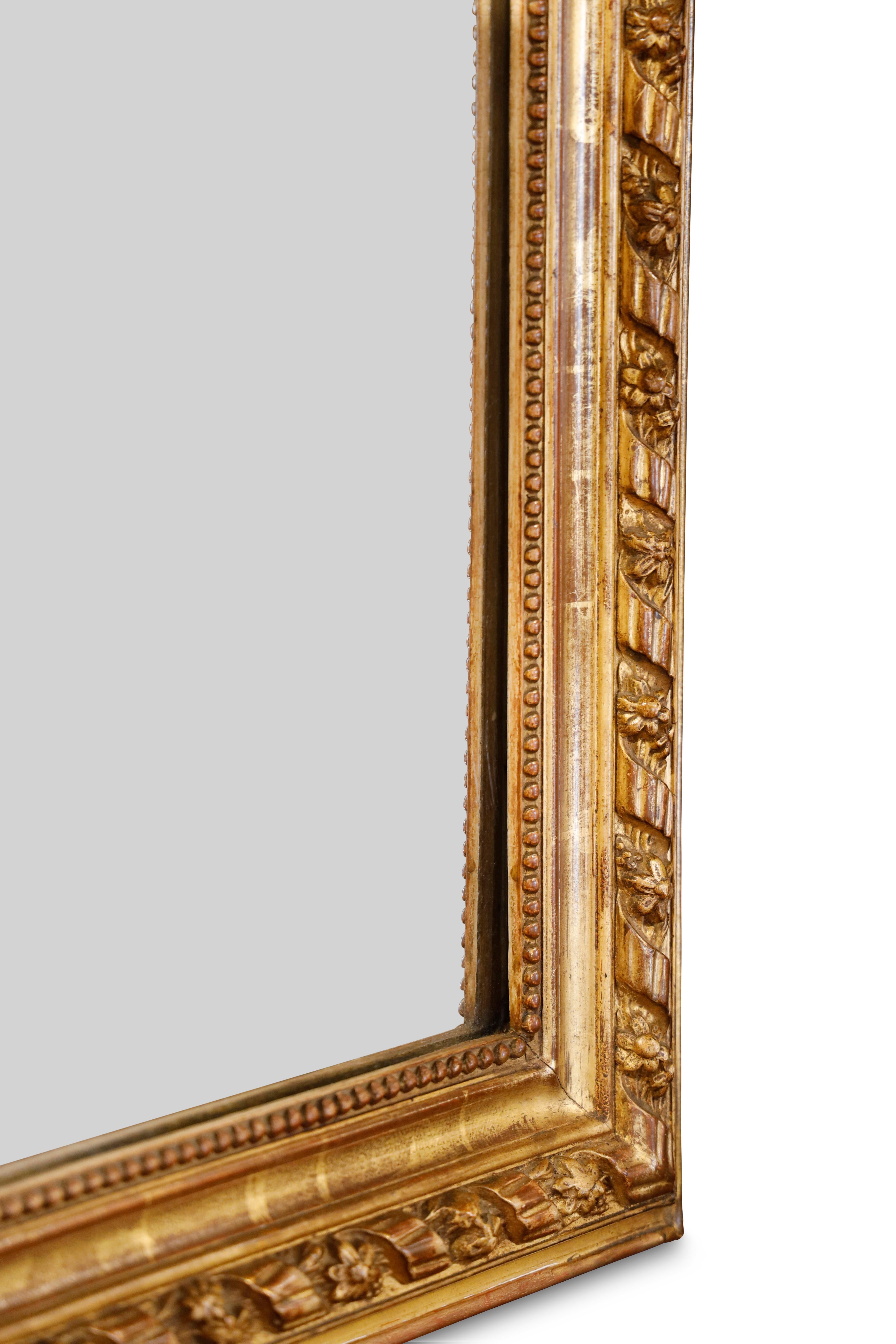 Specchio francese in legno d'orato con cresta di cammello, intagliato a corda intrecciata e disegno floreale, affiancato da una cornice interna a baia con bordo bordato.  Vetro originale.