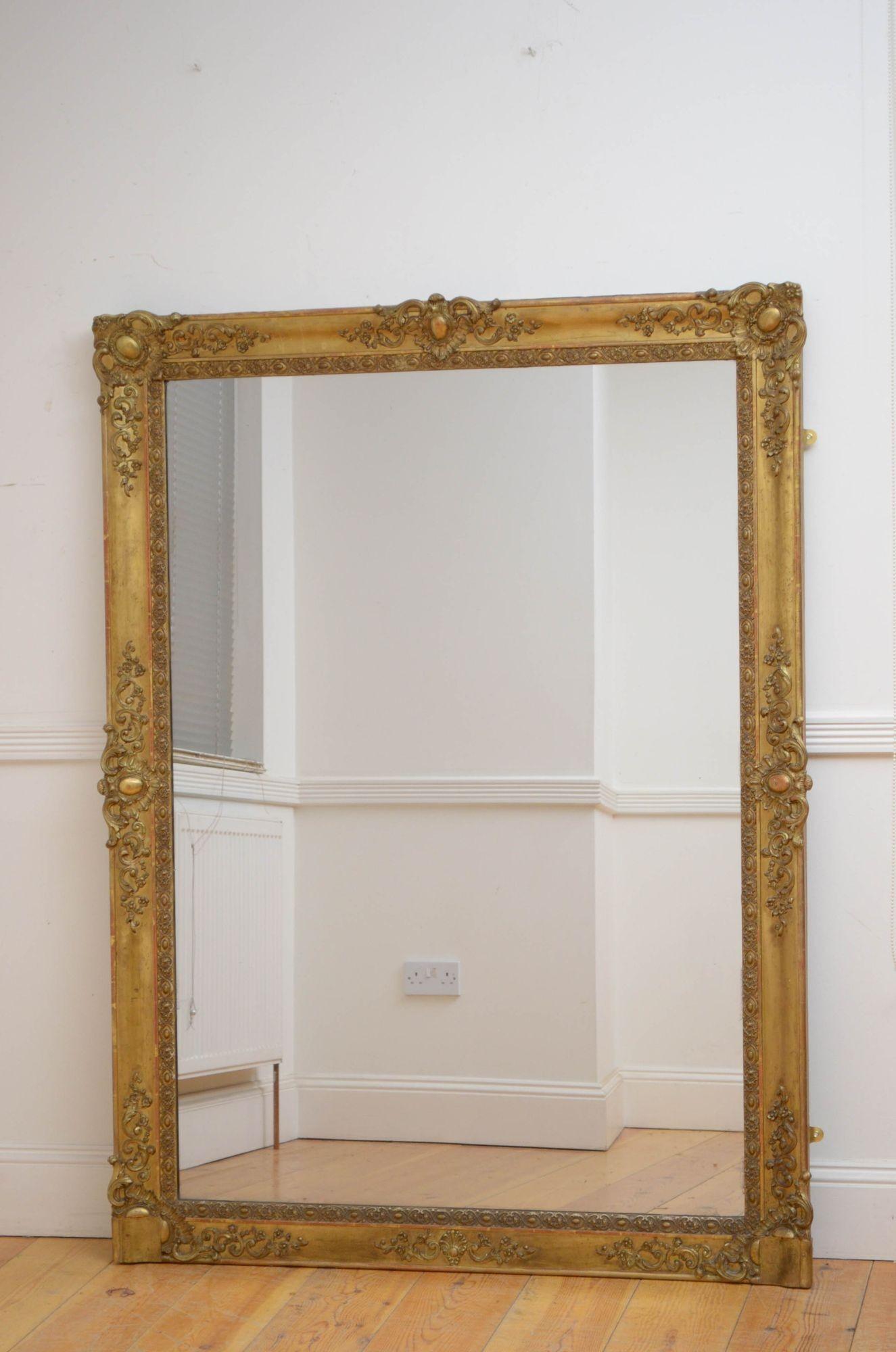 Sn5290 Attractive 19th century gilded wall mirror with original glass with air bubbles and some foxing in gilded frame with decorative floral carvings to corners. This antique mirror retains its original glass, gilt and backboards, all in excellent