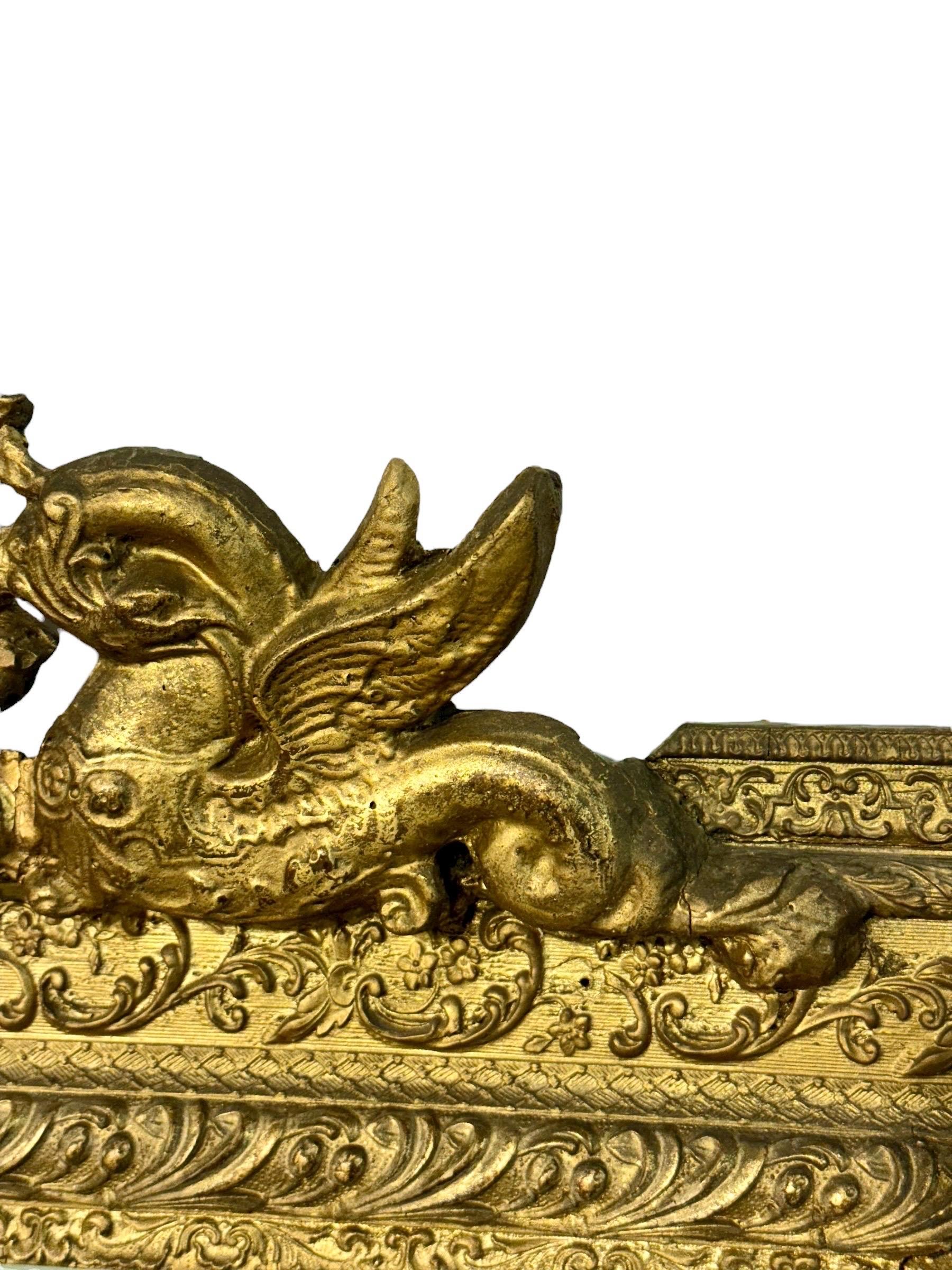 Elegante espejo francés de madera dorada del siglo XIX ricamente decorado en estilo Luis XVI. El marco rectangular está finamente tallado con intrincados motivos florales y foliados, realzados por un bello acabado dorado envejecido. Su cimera