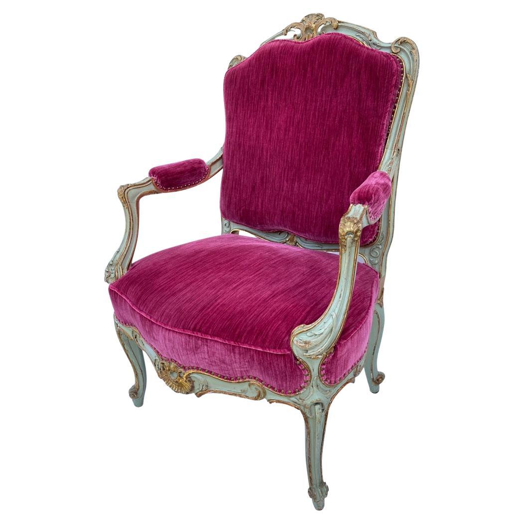 Finely-carved sturdy and comfortable giltwood armchairs. Paint is most likely not original. Newly-upholstered in a raspberry velvet strie.