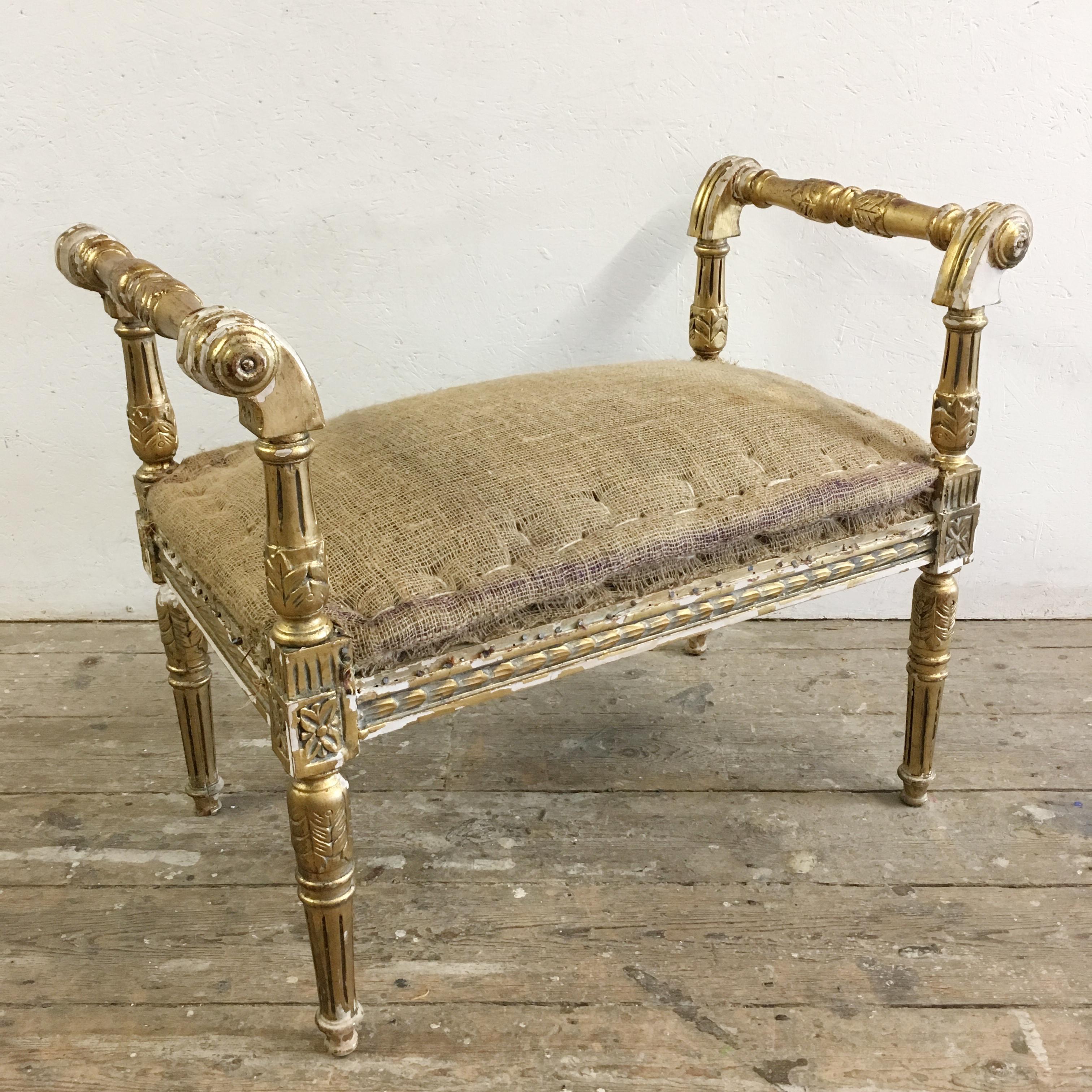 Classical French giltwood window seat. 
Louis XVI style. 
The stool has raised arms, scrolled corner details, acanthus carvings and reeded legs. 
The seat is deeply padded and extremely comfortable, it is in a hessian for immediate use as is or